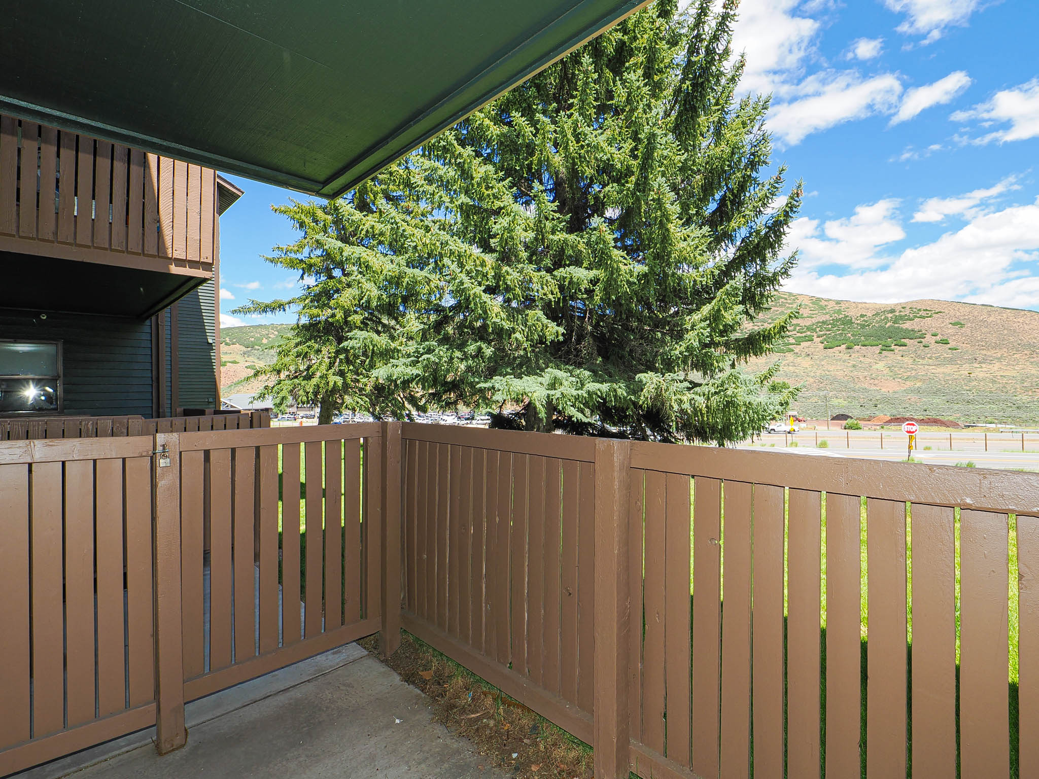 Private patio area featuring a brown slatted fence and concrete flooring