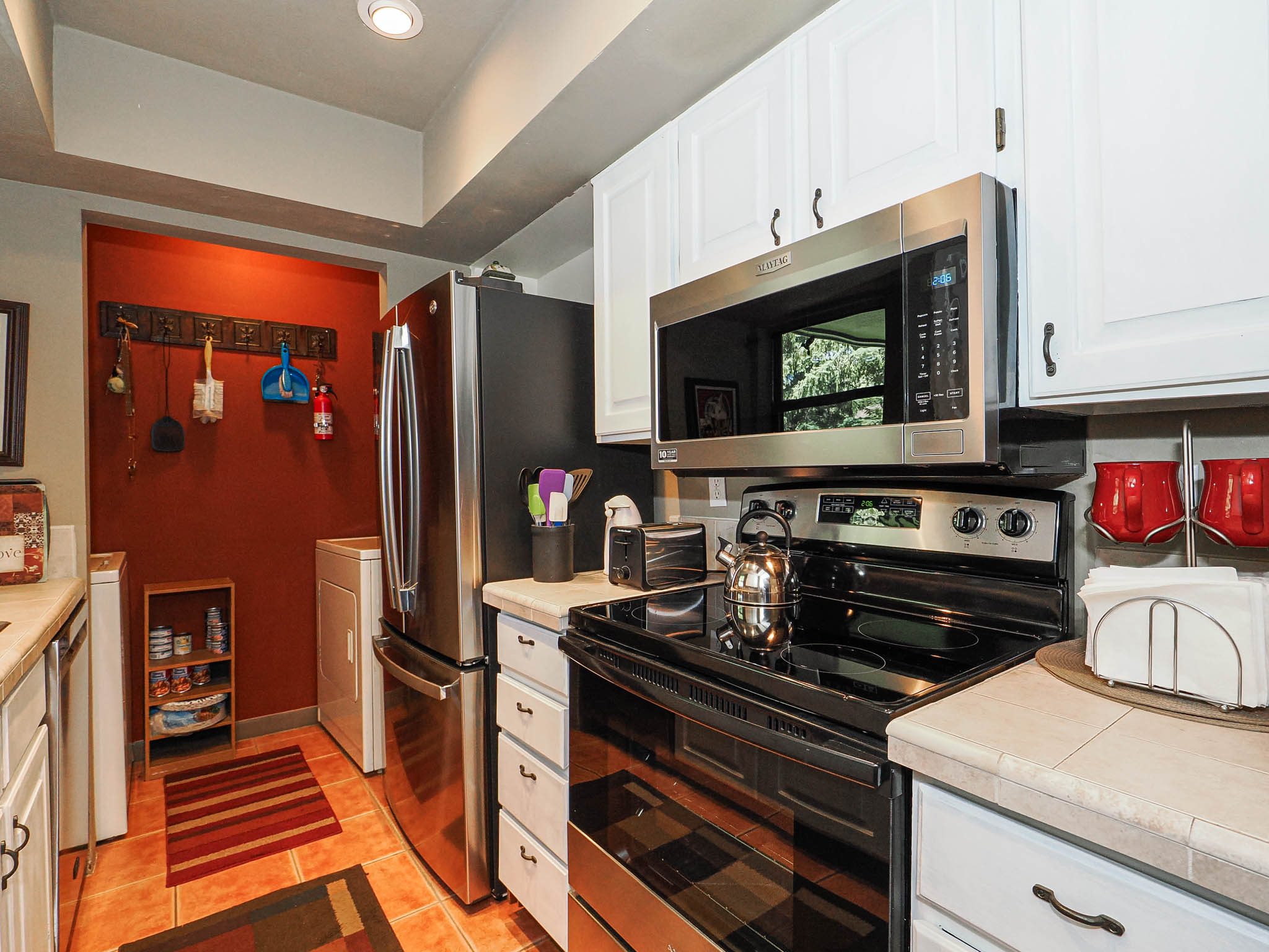 Kitchen features stainless steel appliances, including an over-the-range microwave and a full-size refrigerator