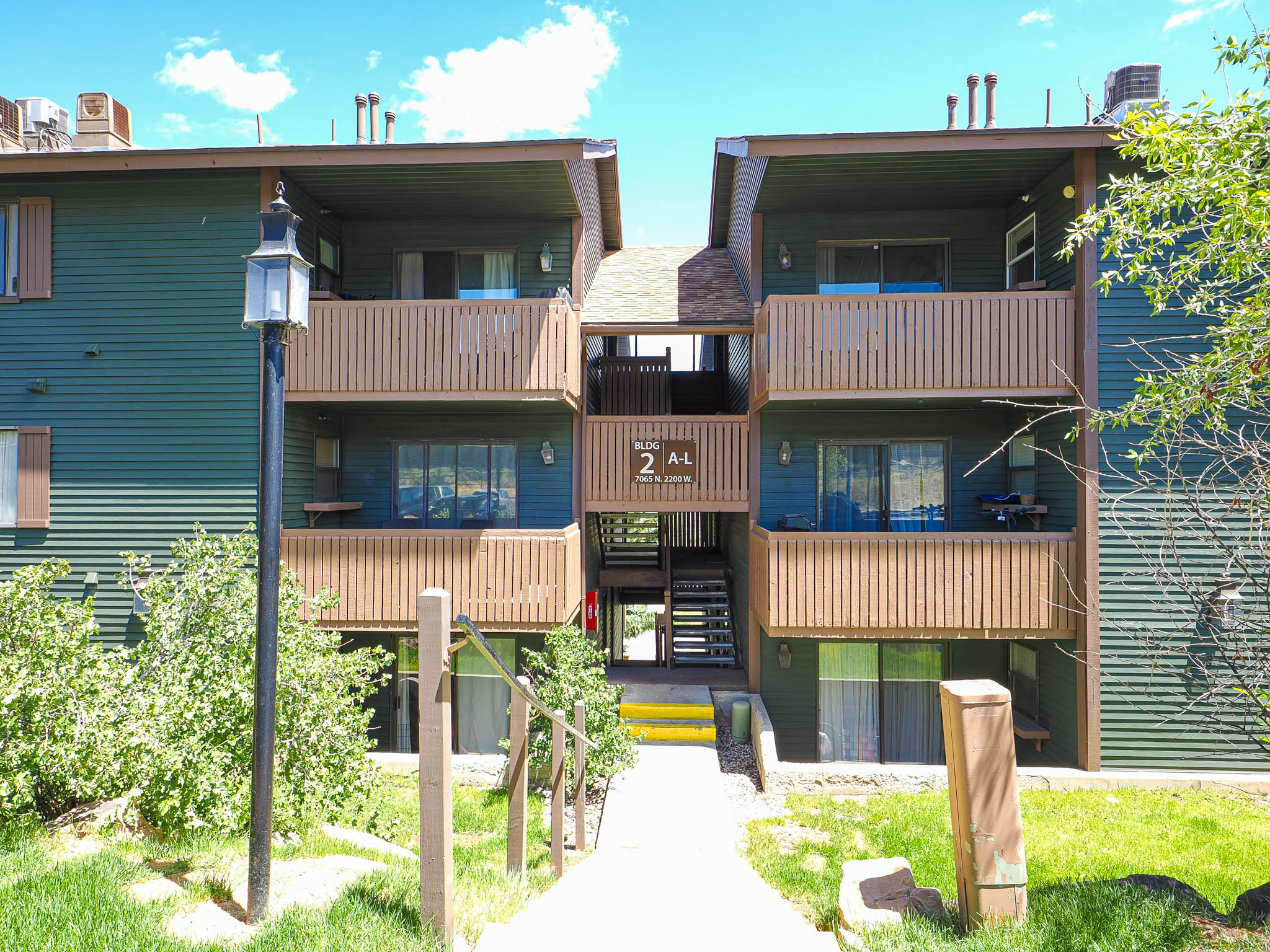 Multi-level building with green siding and brown trim