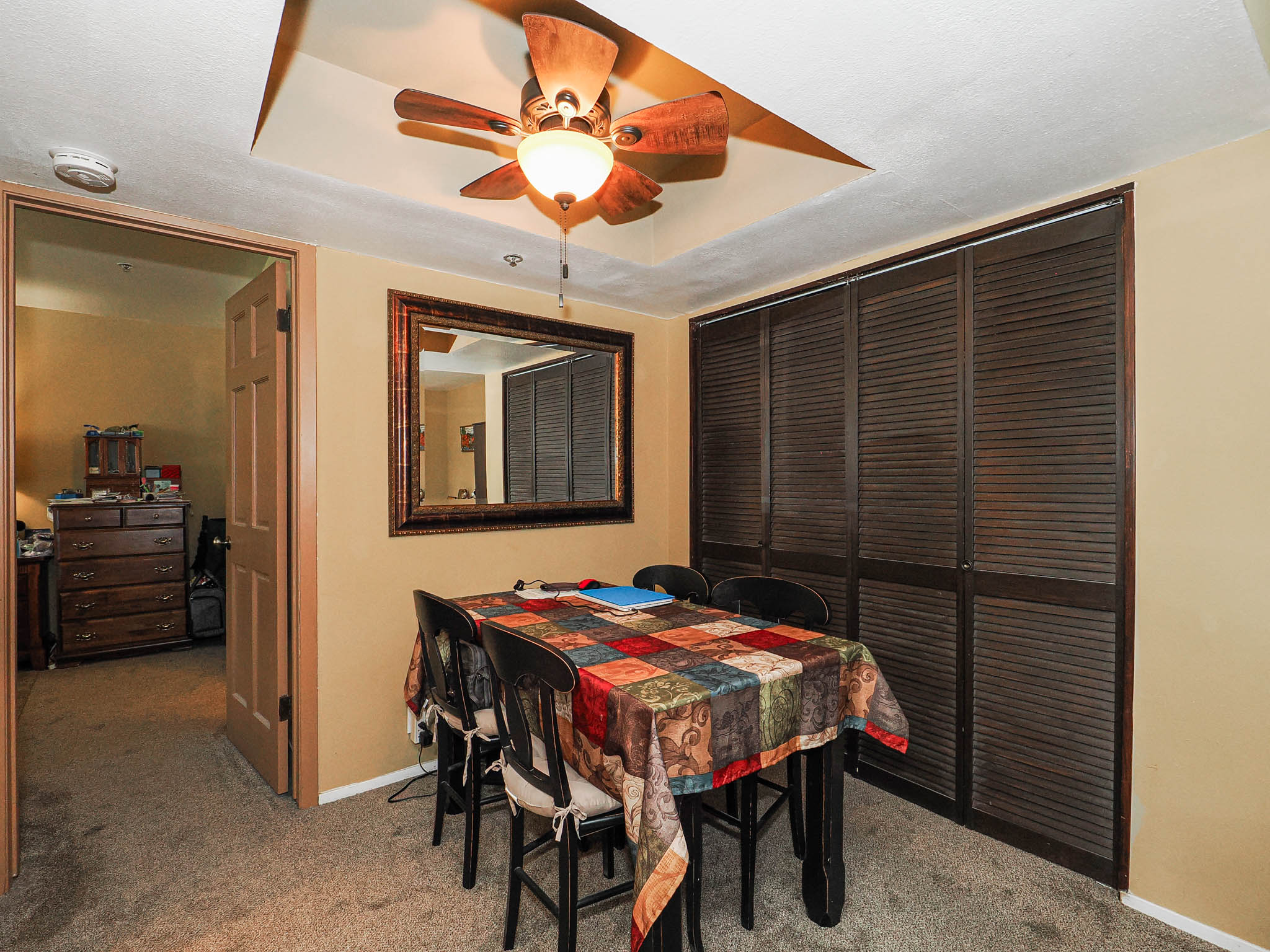 Tray ceiling featuring a ceiling fan with integrated lighting