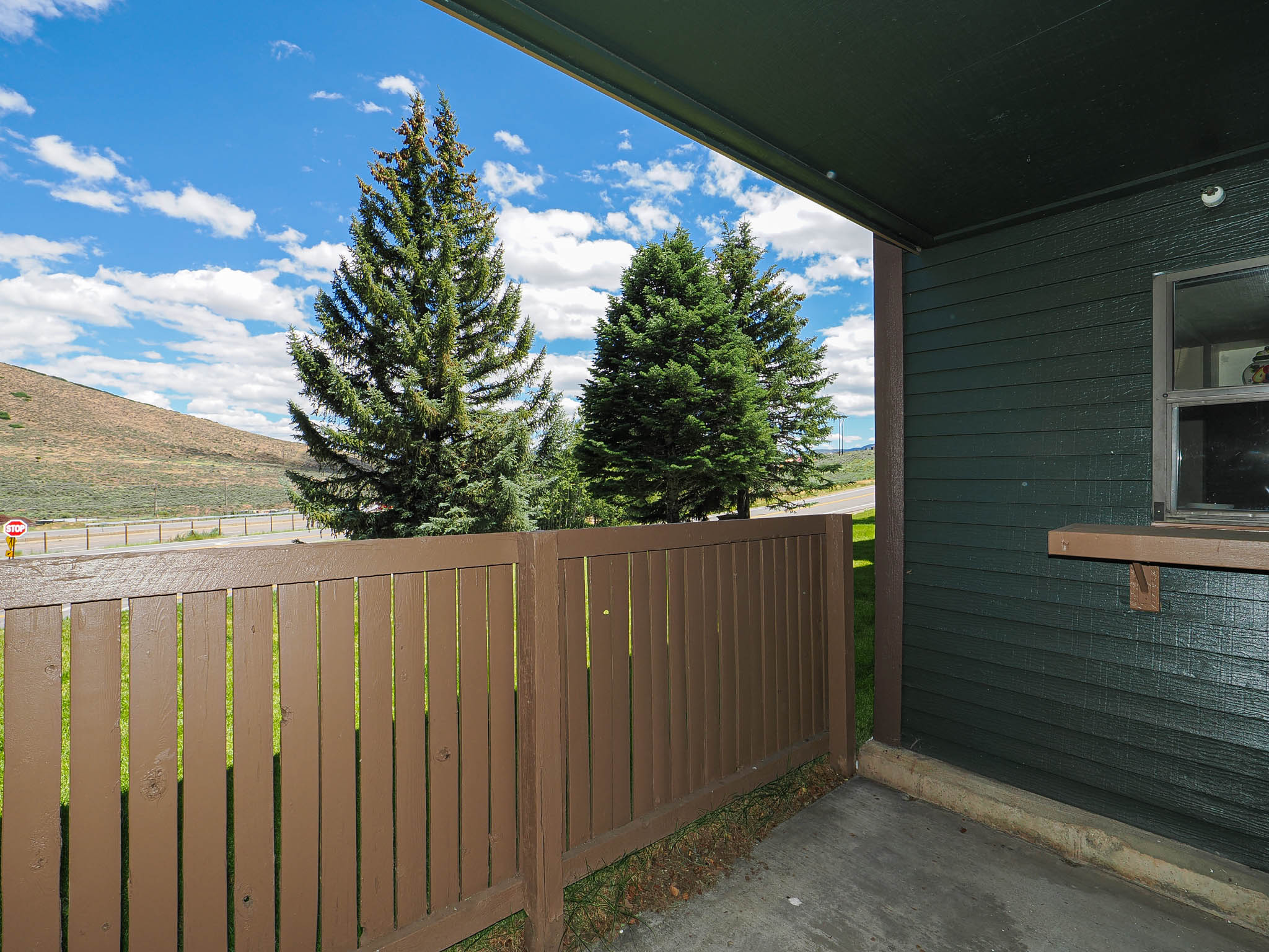 Covered patio featuring a concrete slab and a brown privacy fence