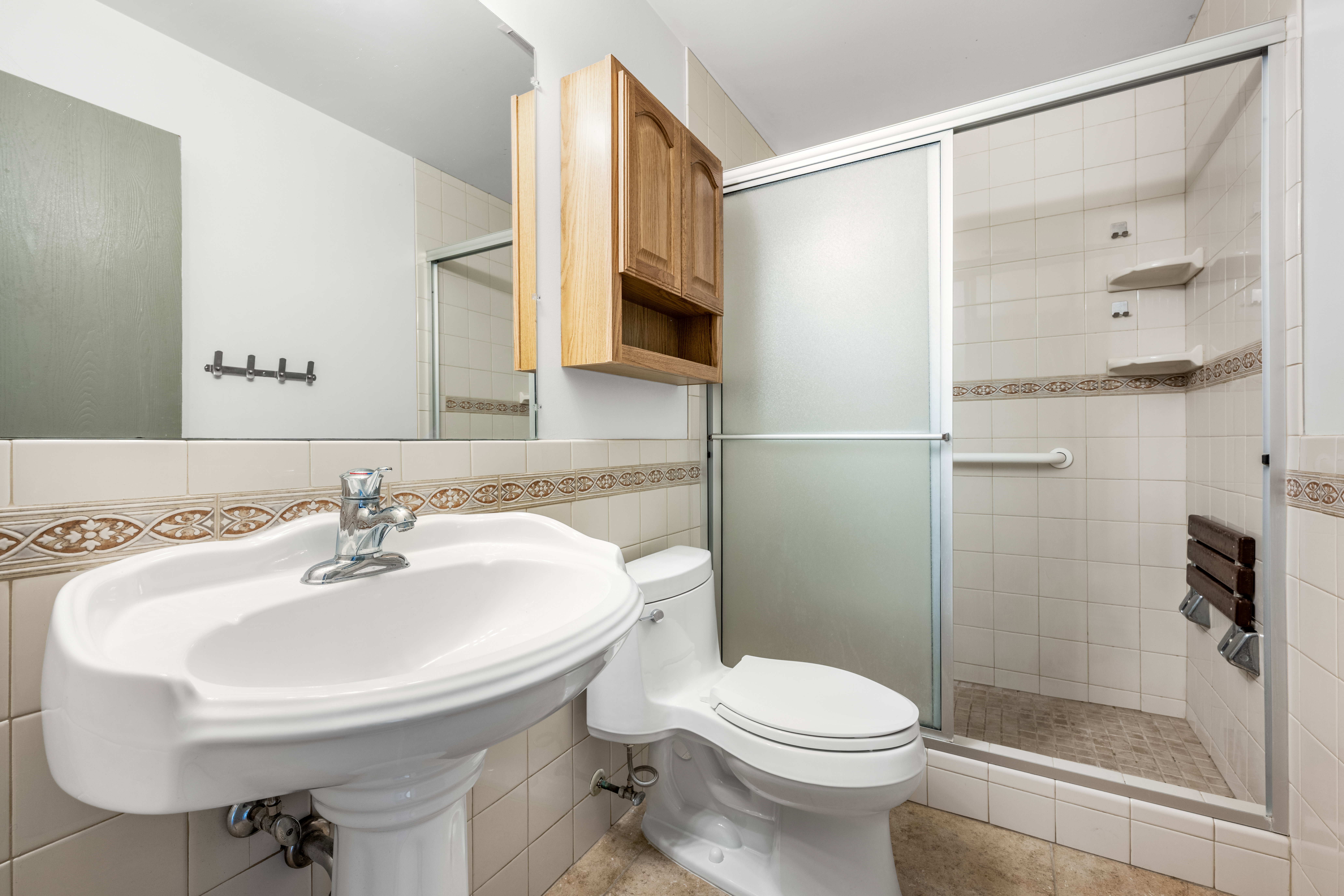 Bathroom featuring a pedestal sink, a toilet, and a shower enclosure with a sliding frosted glass door