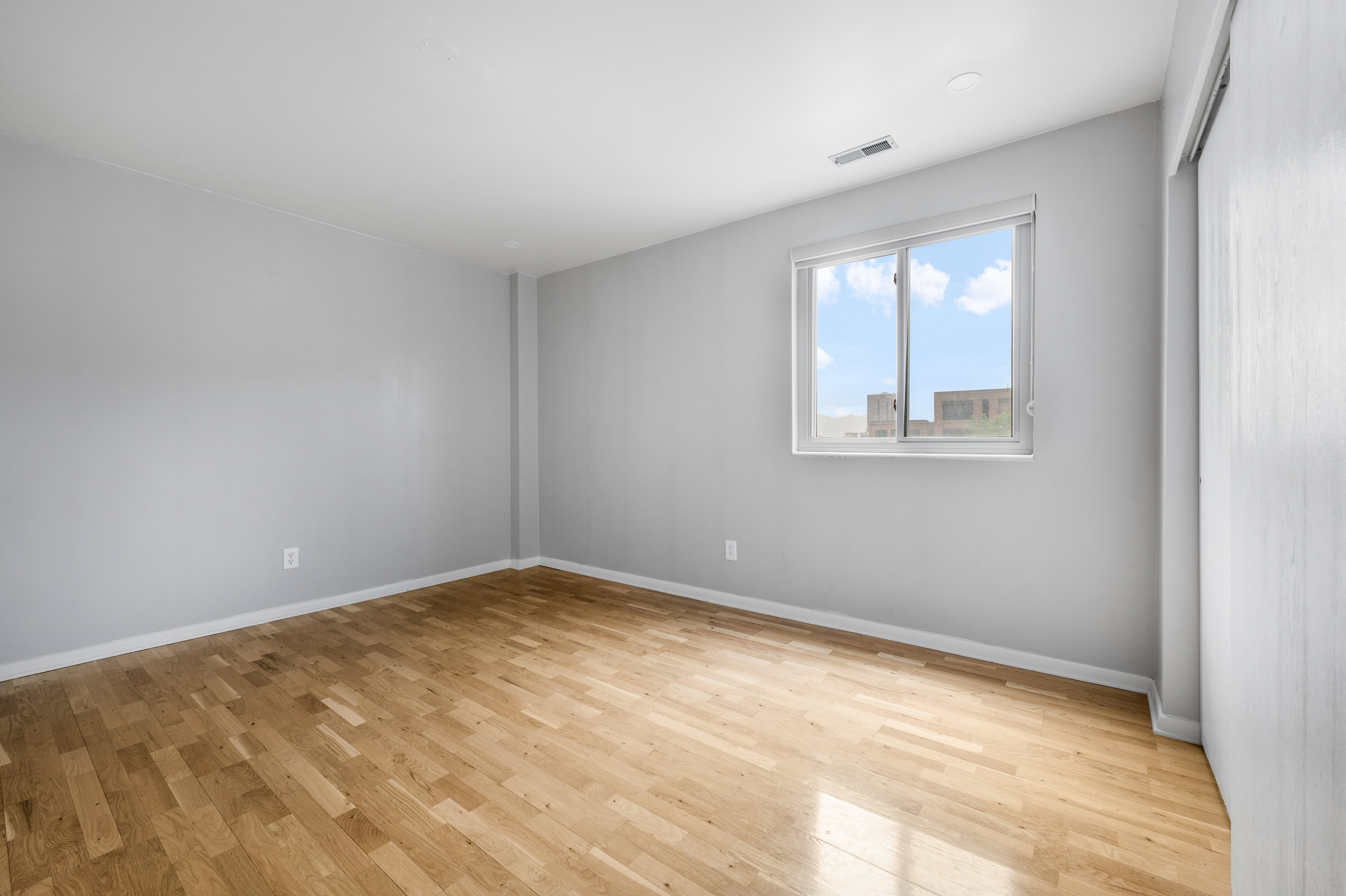 Room featuring light wood-finish flooring, light gray wall paint, and white trim