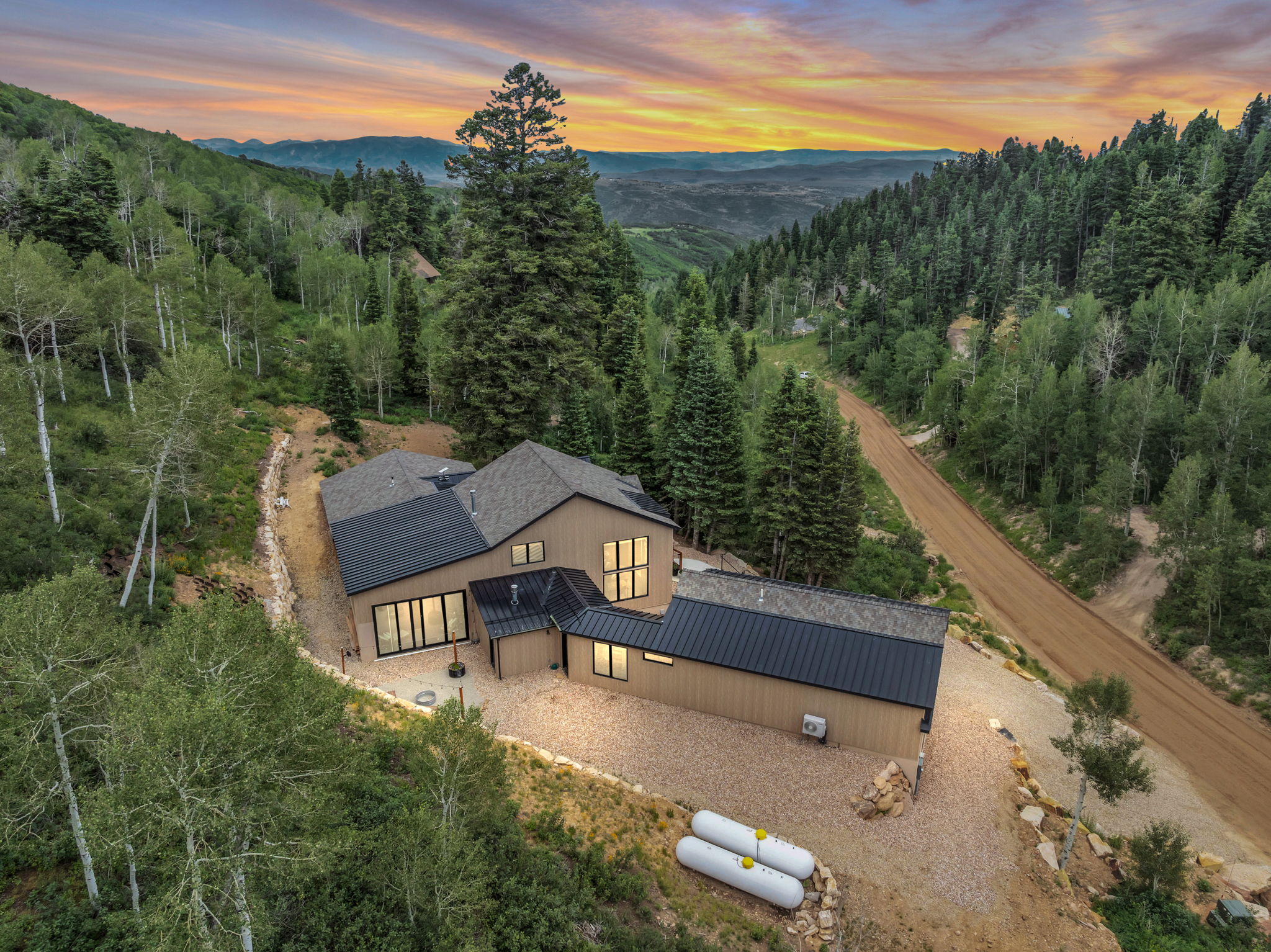 Modern mountain residence featuring a multi-level design and a combination of shingle and metal roofing