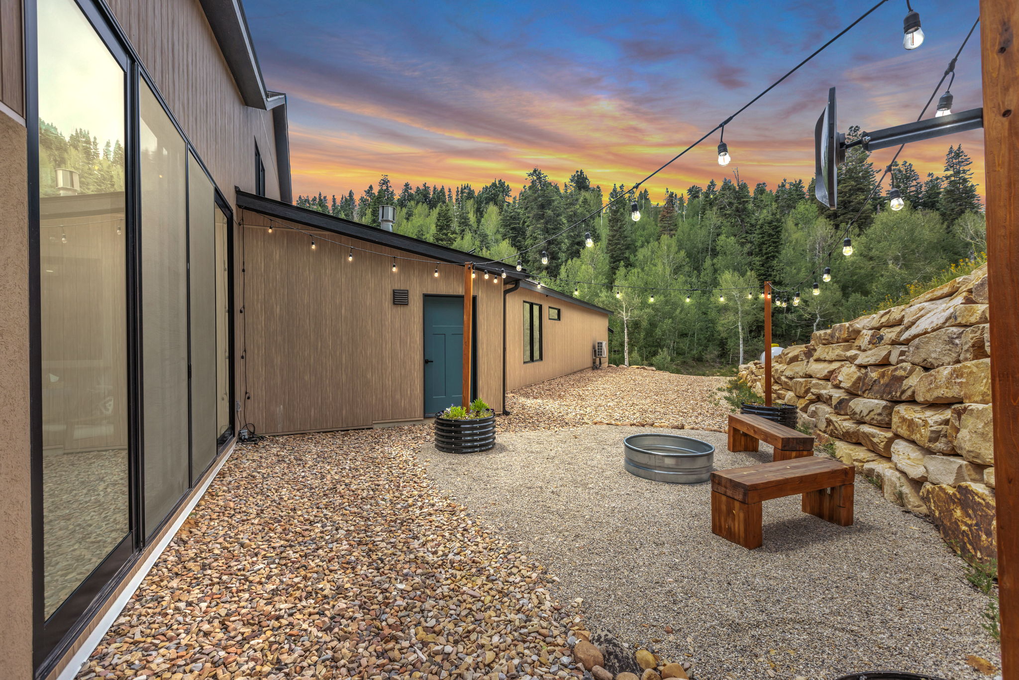 Exterior patio featuring gravel surfacing and a large rock retaining wall