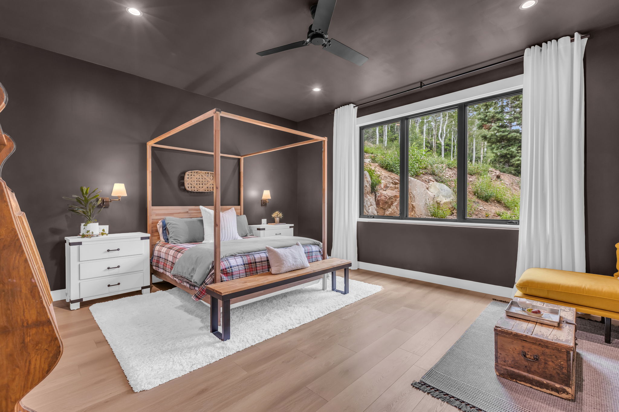 Expansive window overlooking natural rock formations and abundant trees