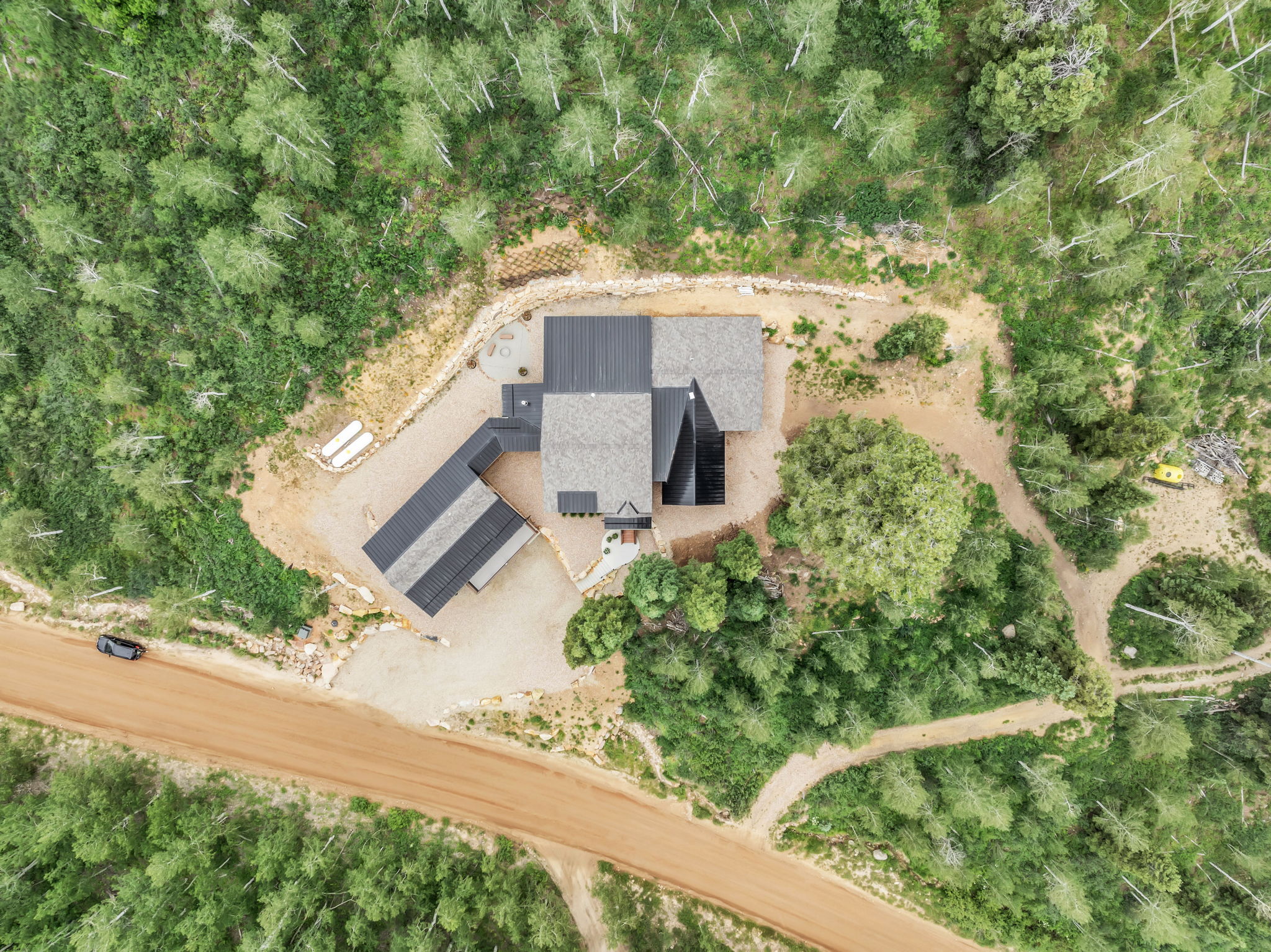 Contemporary residence with a multi-level roofline, surrounded by dense natural foliage