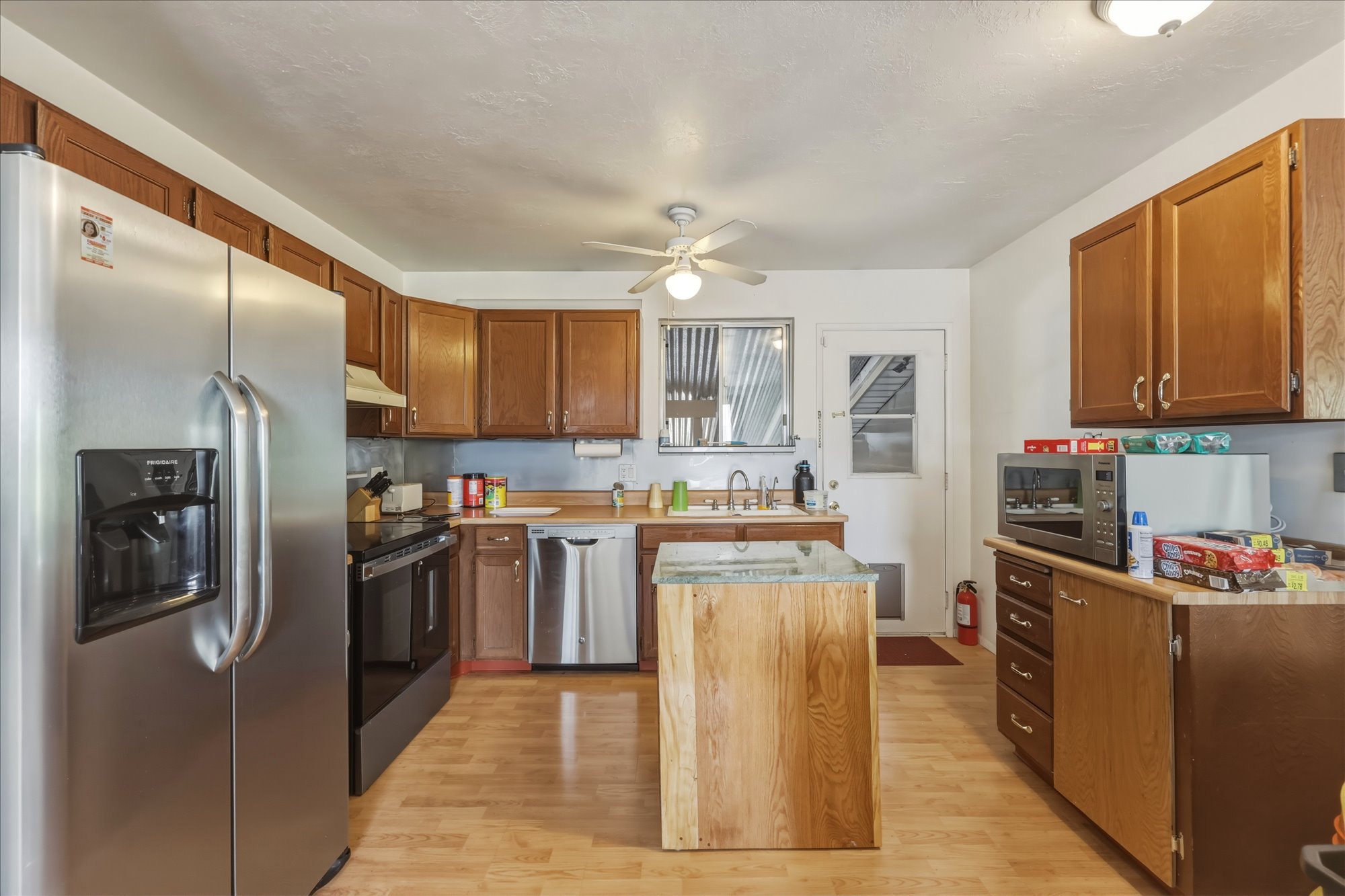 Kitchen featuring wood-finish flooring, stainless steel appliances, and wood cabinetry