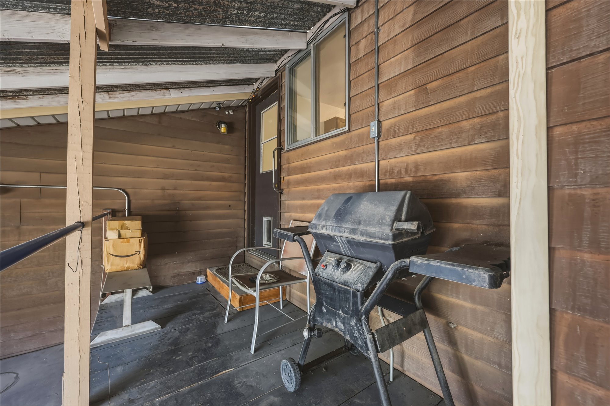 Covered outdoor patio with a plank wood floor and shiplap exterior wall