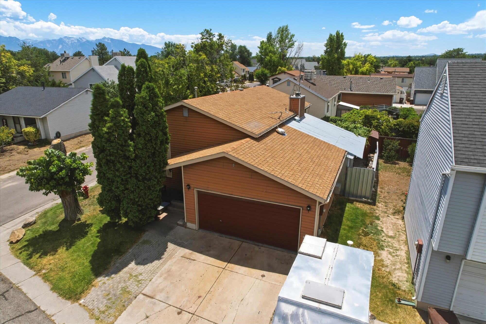 Split-level residence featuring a two-car garage with a brown door