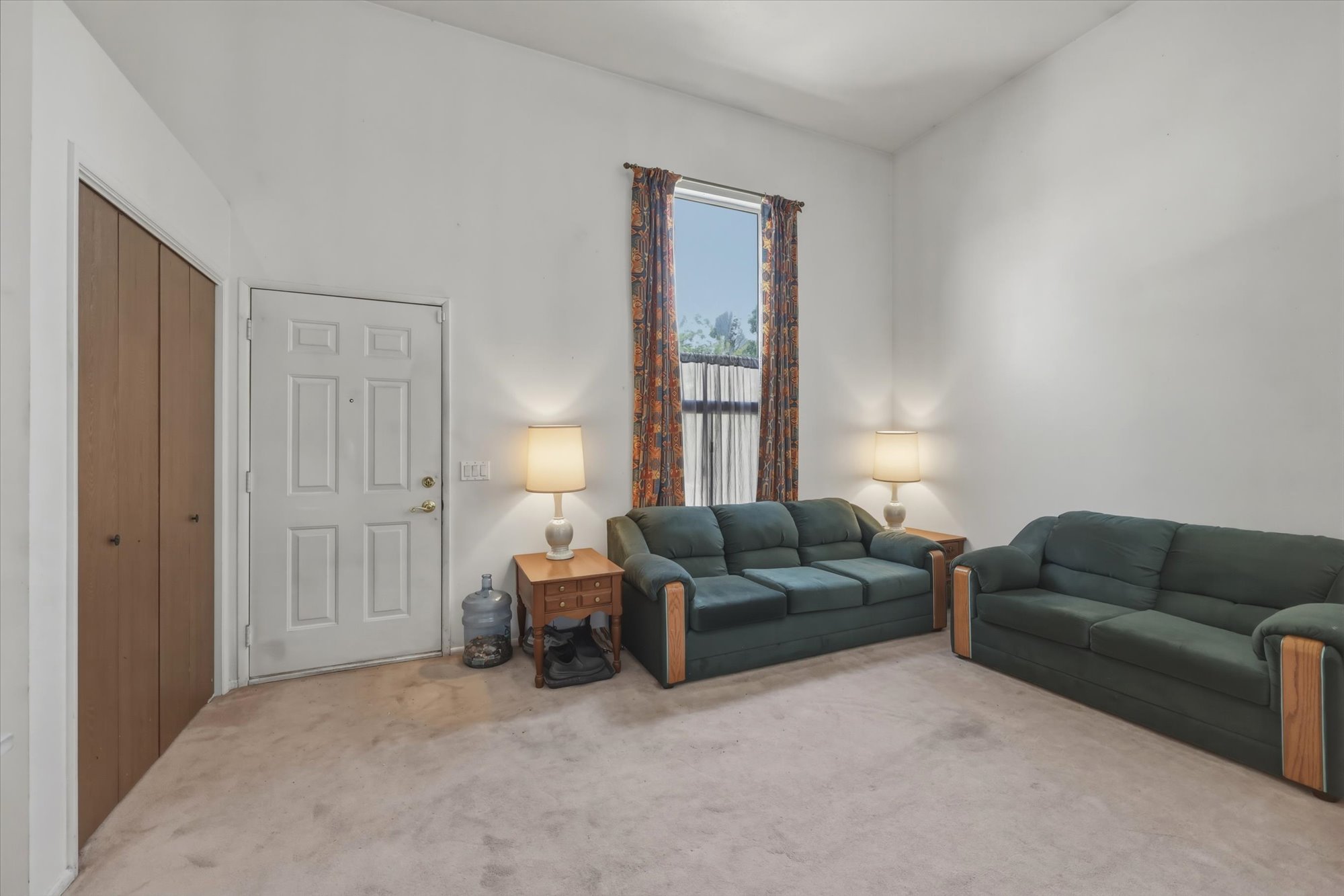 Neutral-toned carpeting complements the white walls and high ceilings