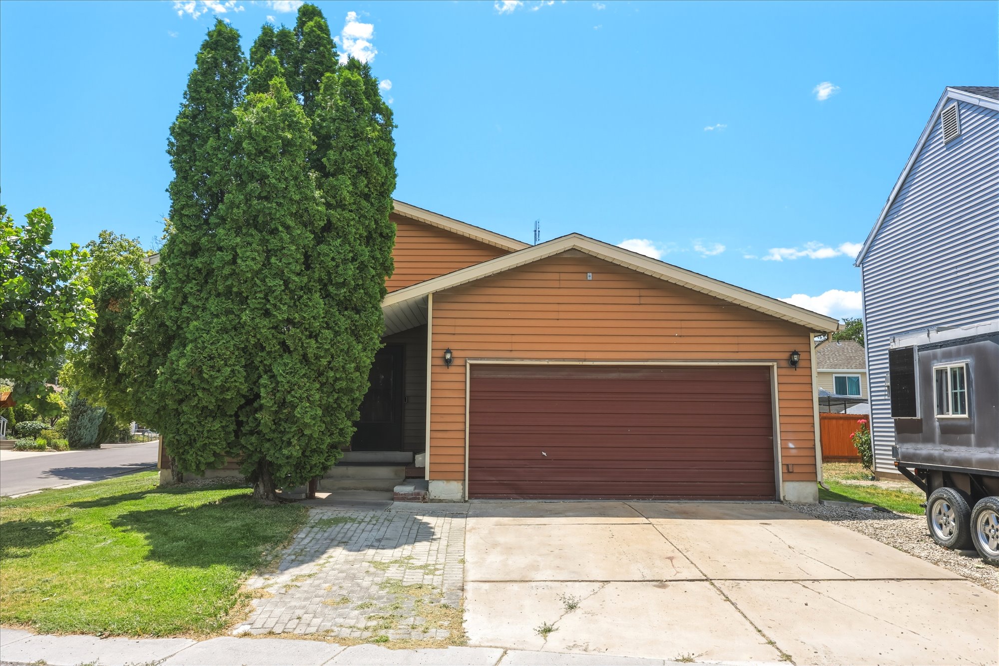 Front exterior featuring wood-look siding and a prominent two-car garage with a brown door