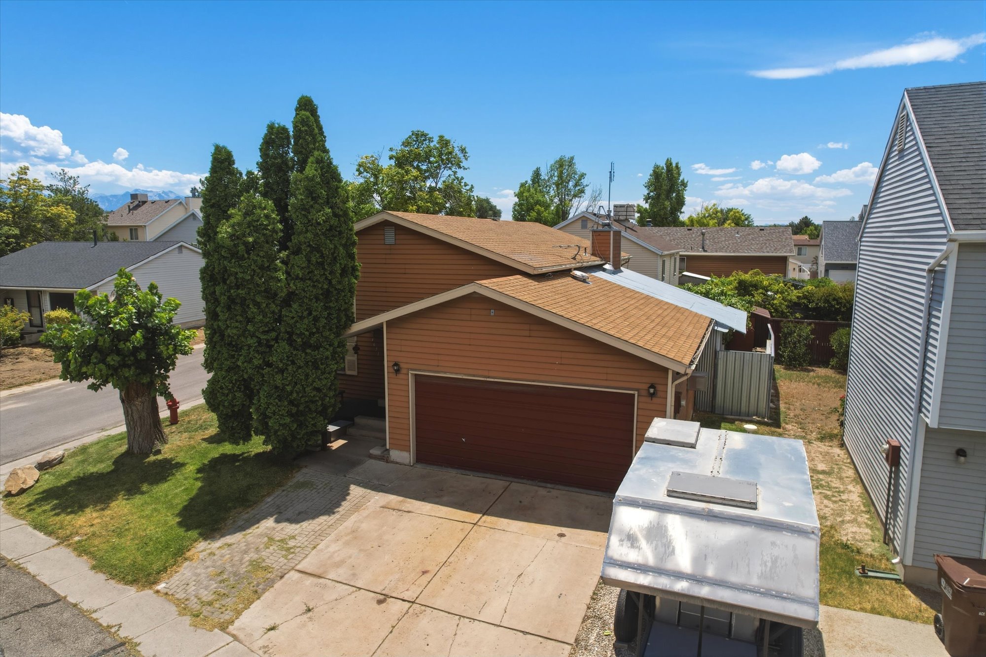 Two-story residence featuring horizontal brown siding and an attached single-car garage with a dark wood-finish door