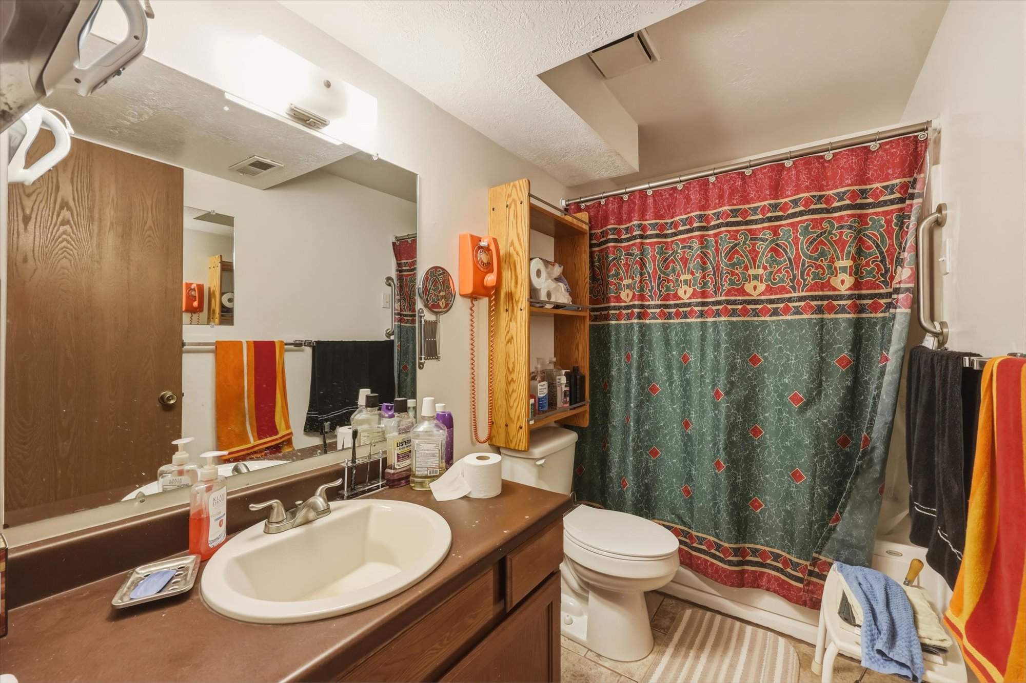 Bathroom vanity with a white oval sink, chrome faucet, and a large wall-mounted mirror
