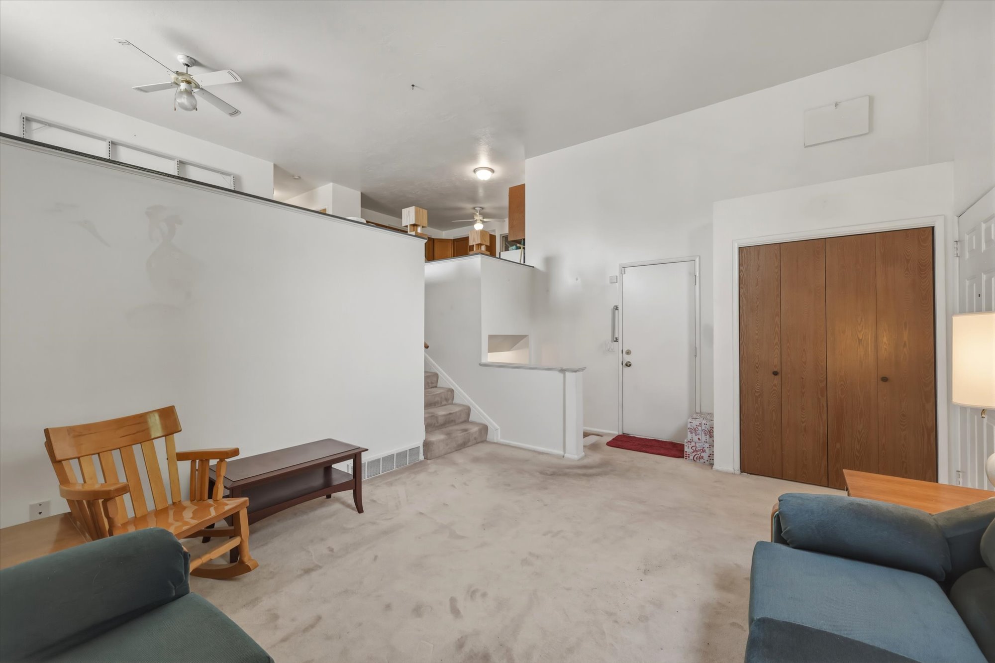 Carpeted living area featuring a vaulted ceiling and a ceiling fan
