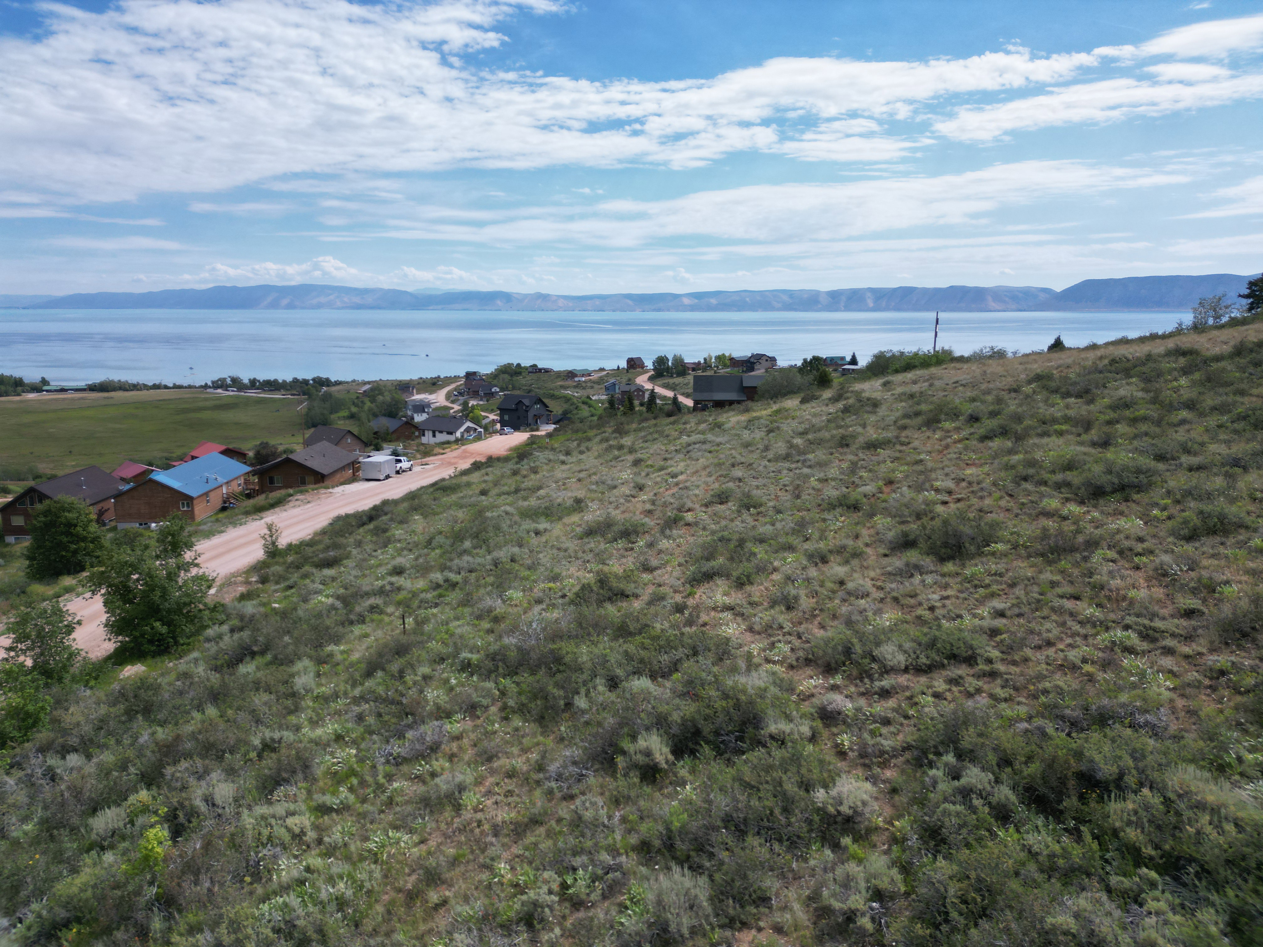 Expansive elevated terrain featuring natural shrubbery and a partial dirt road