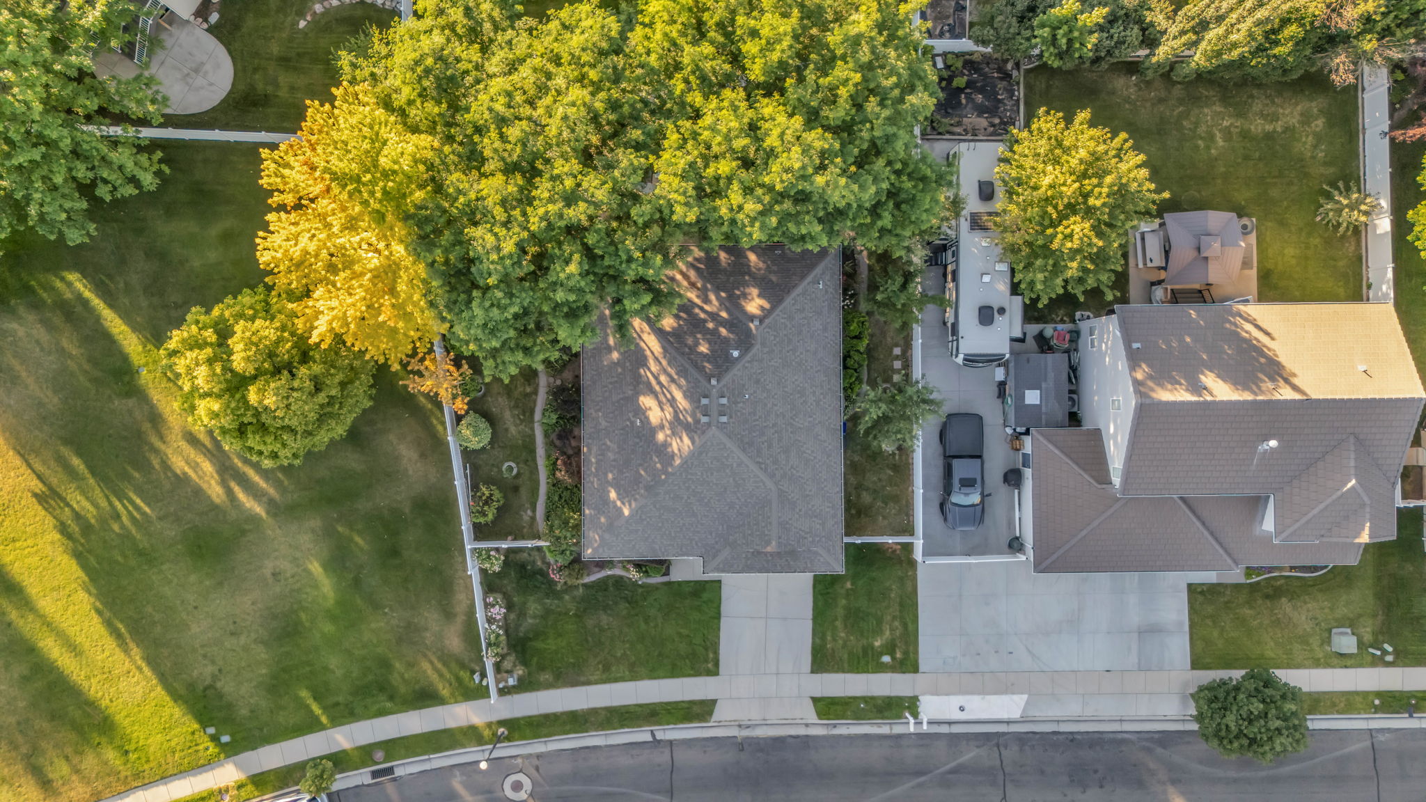 Aerial view showcasing a residential property with a gabled roof and surrounding mature trees