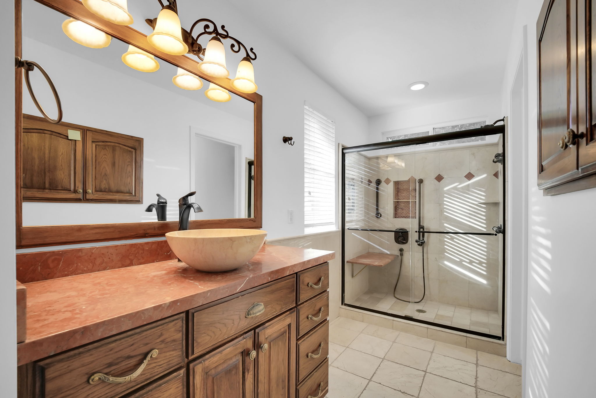 Bathroom featuring a wood-finish vanity with a vessel sink and stone countertop