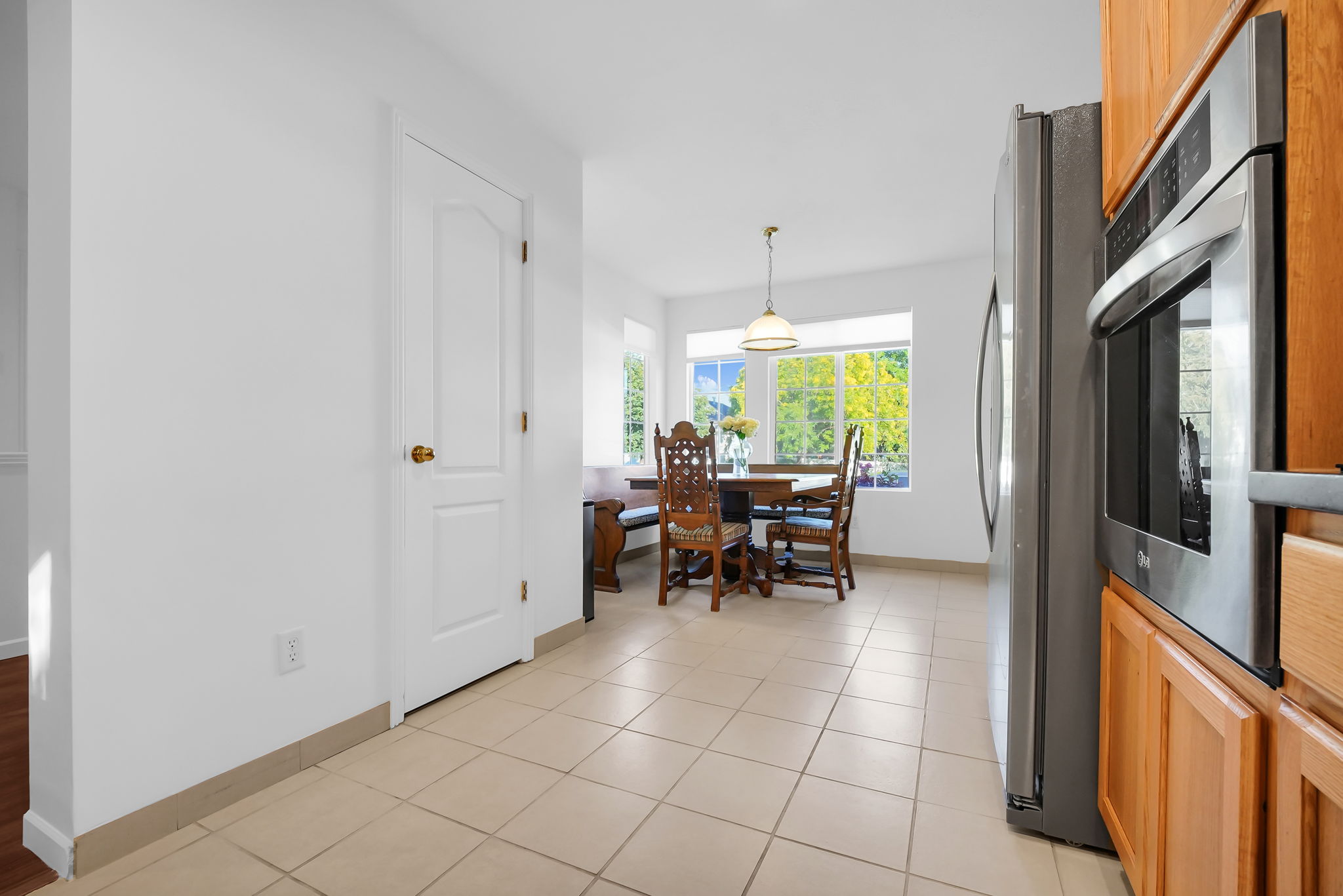 Kitchen area featuring wood-finish cabinetry, stainless steel appliances, and tile flooring