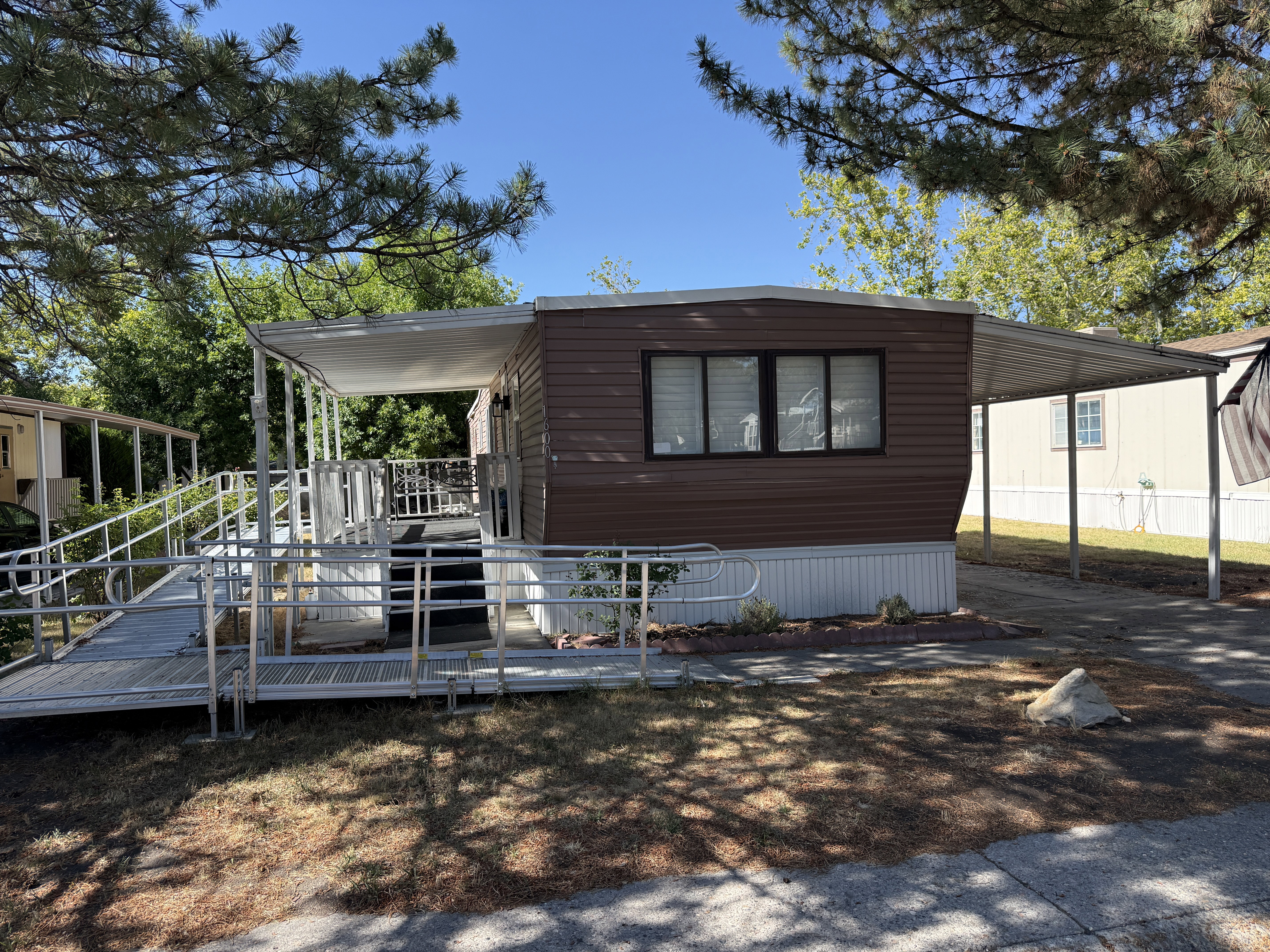 Brown horizontal siding with white trim and a white skirting foundation