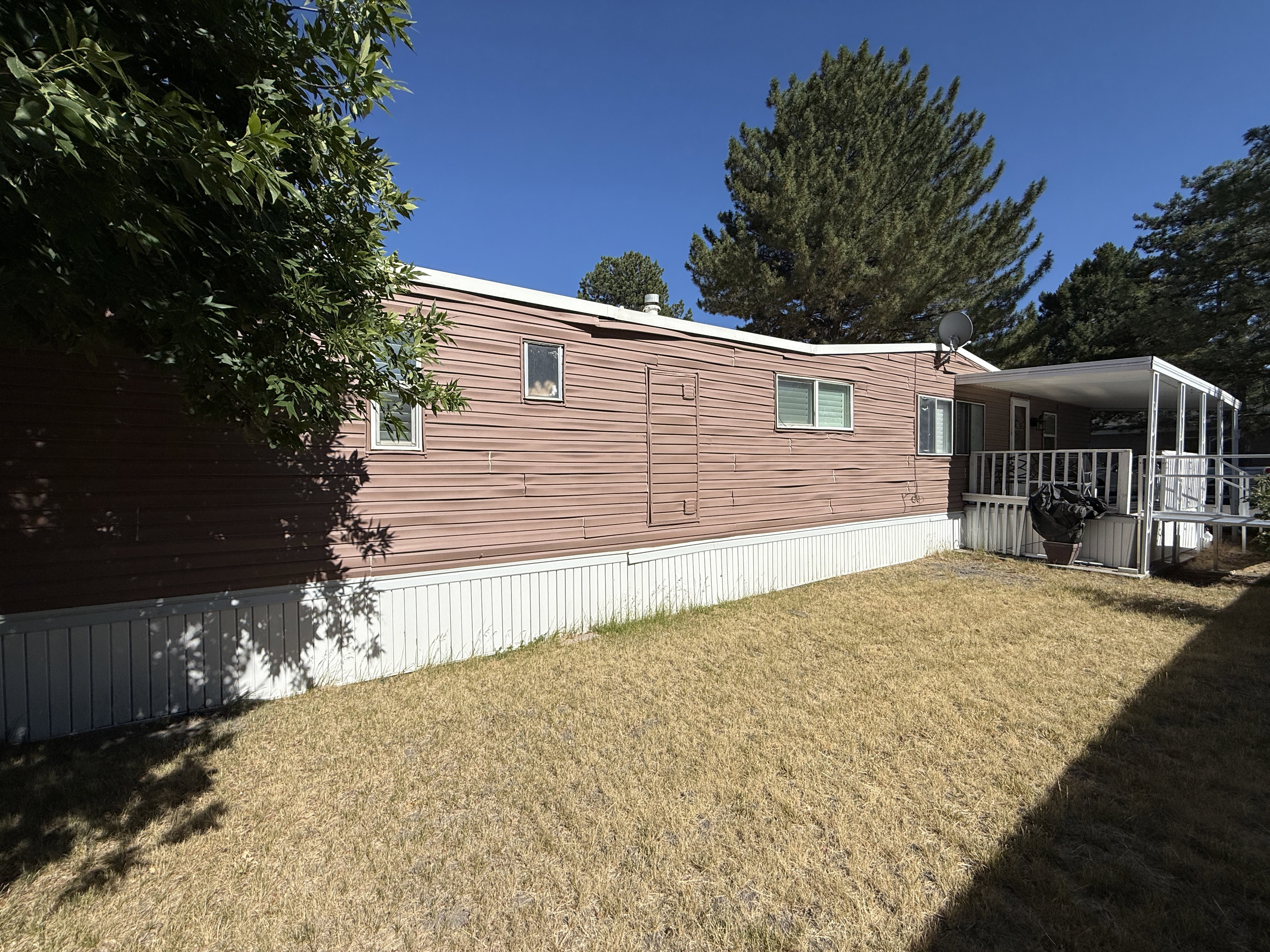 Exterior featuring reddish-brown horizontal siding, white trim, and multiple windows