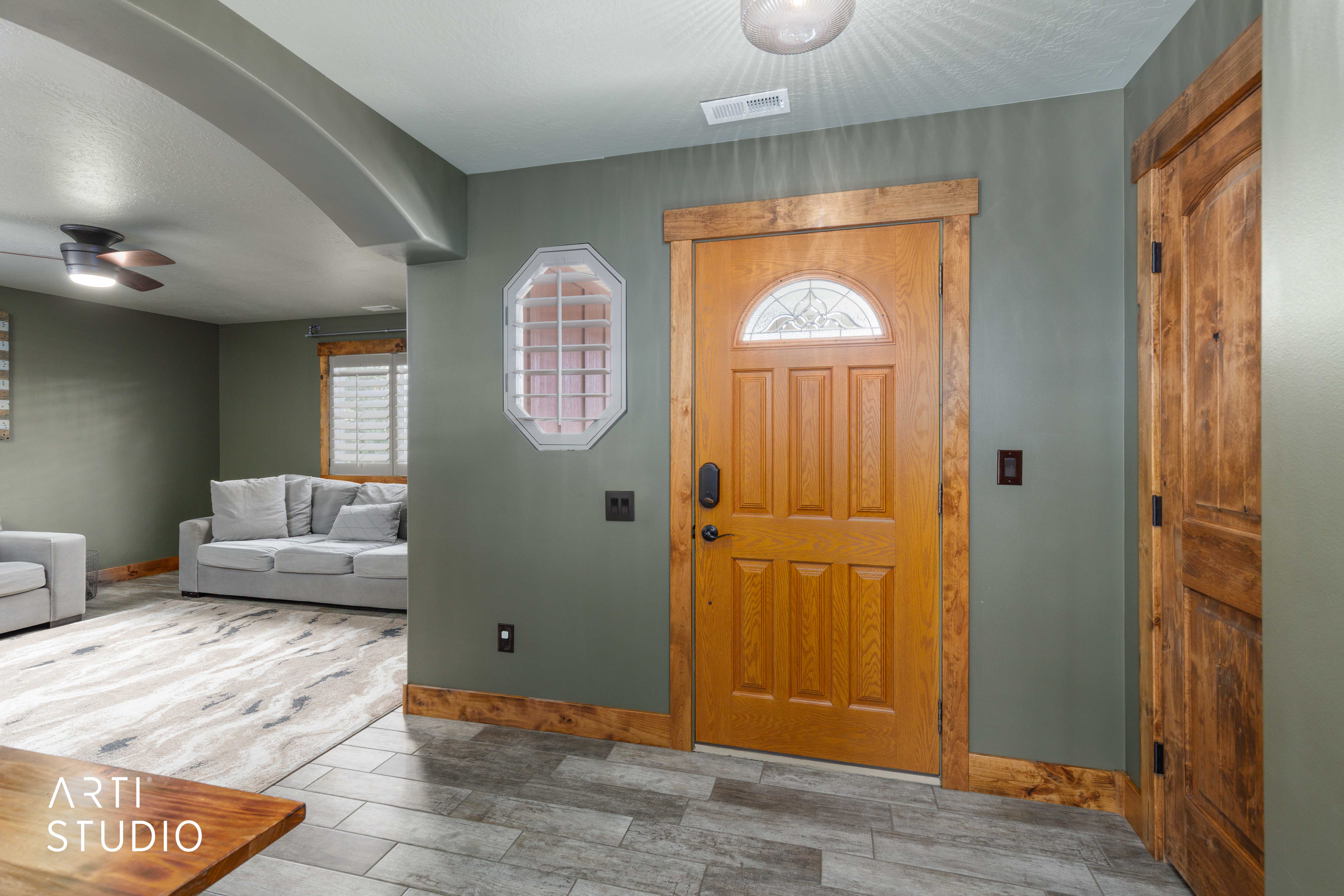Entryway featuring a wood-panel door with decorative glass insert, wood-finish trim, and tile flooring