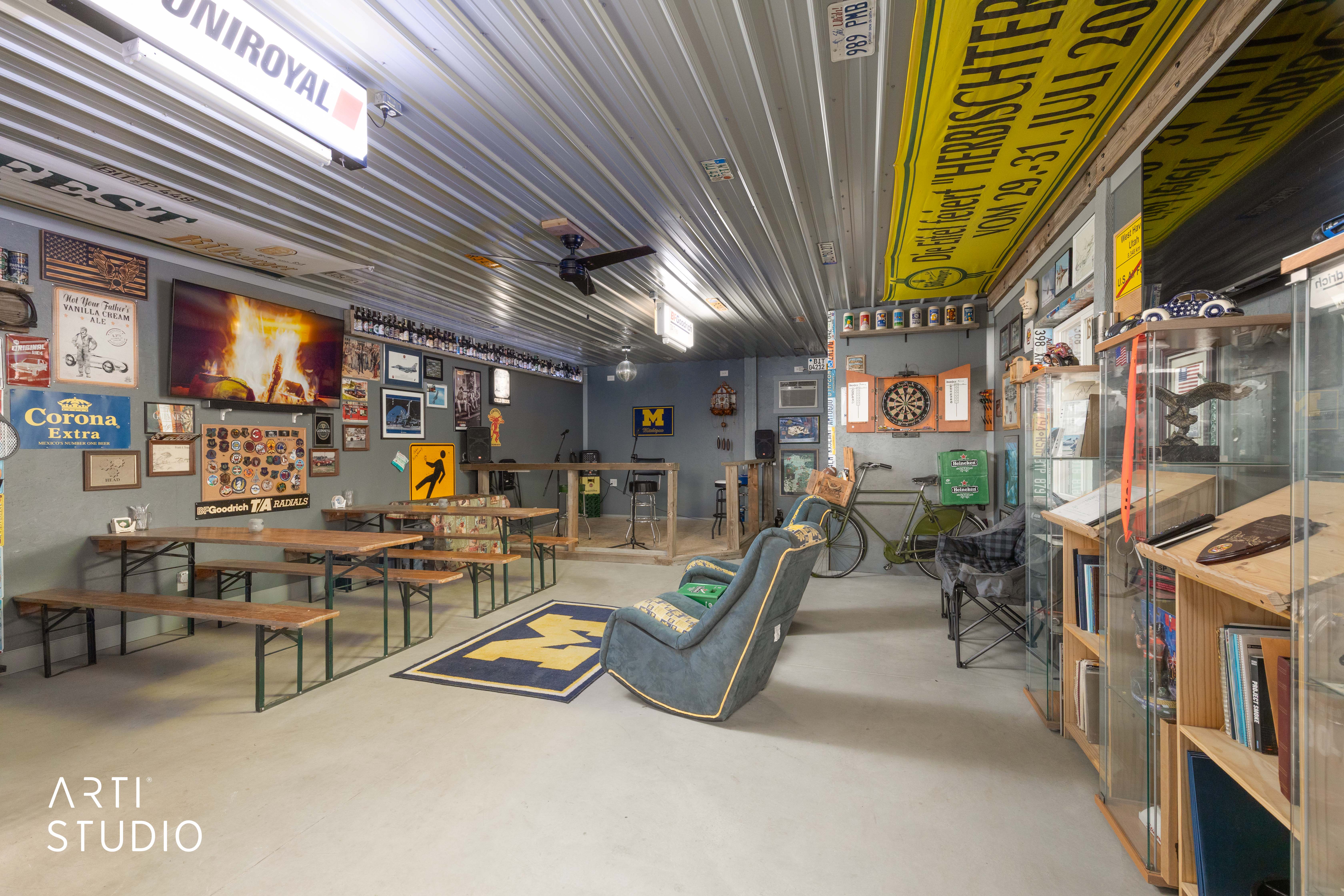Spacious entertainment area featuring a corrugated metal ceiling, ample wall space for display, and durable concrete flooring