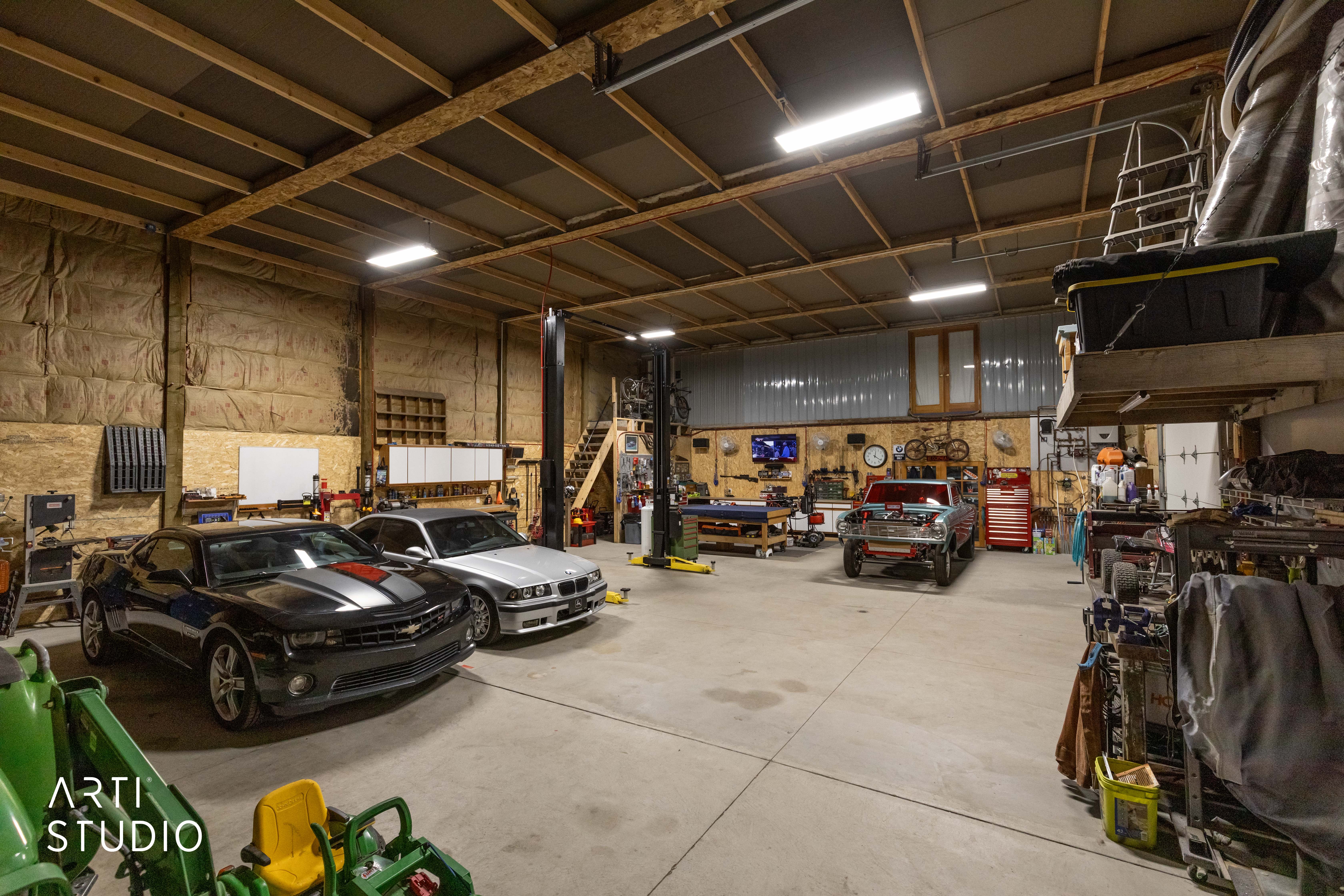 Spacious garage featuring concrete flooring and exposed wood beam ceilings