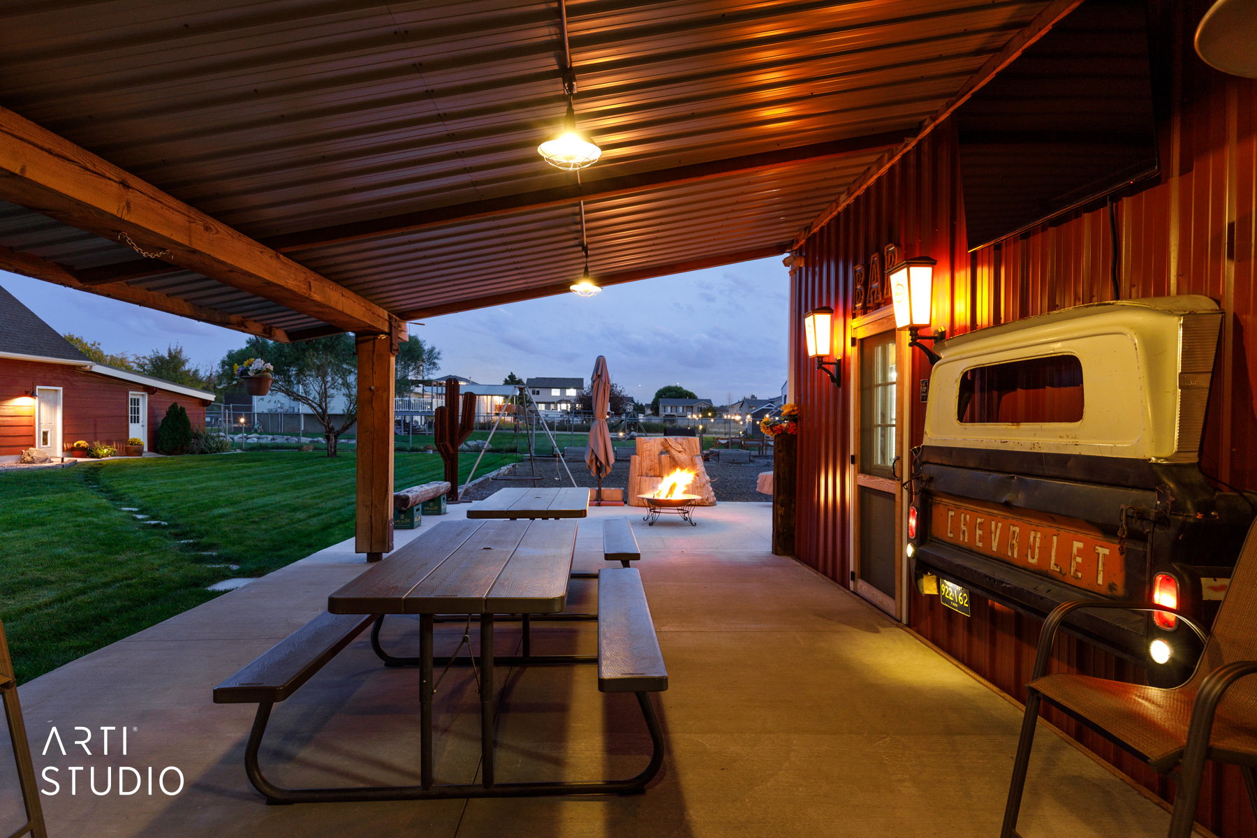 Covered patio featuring a durable metal roof, concrete flooring, and exposed wood beam supports