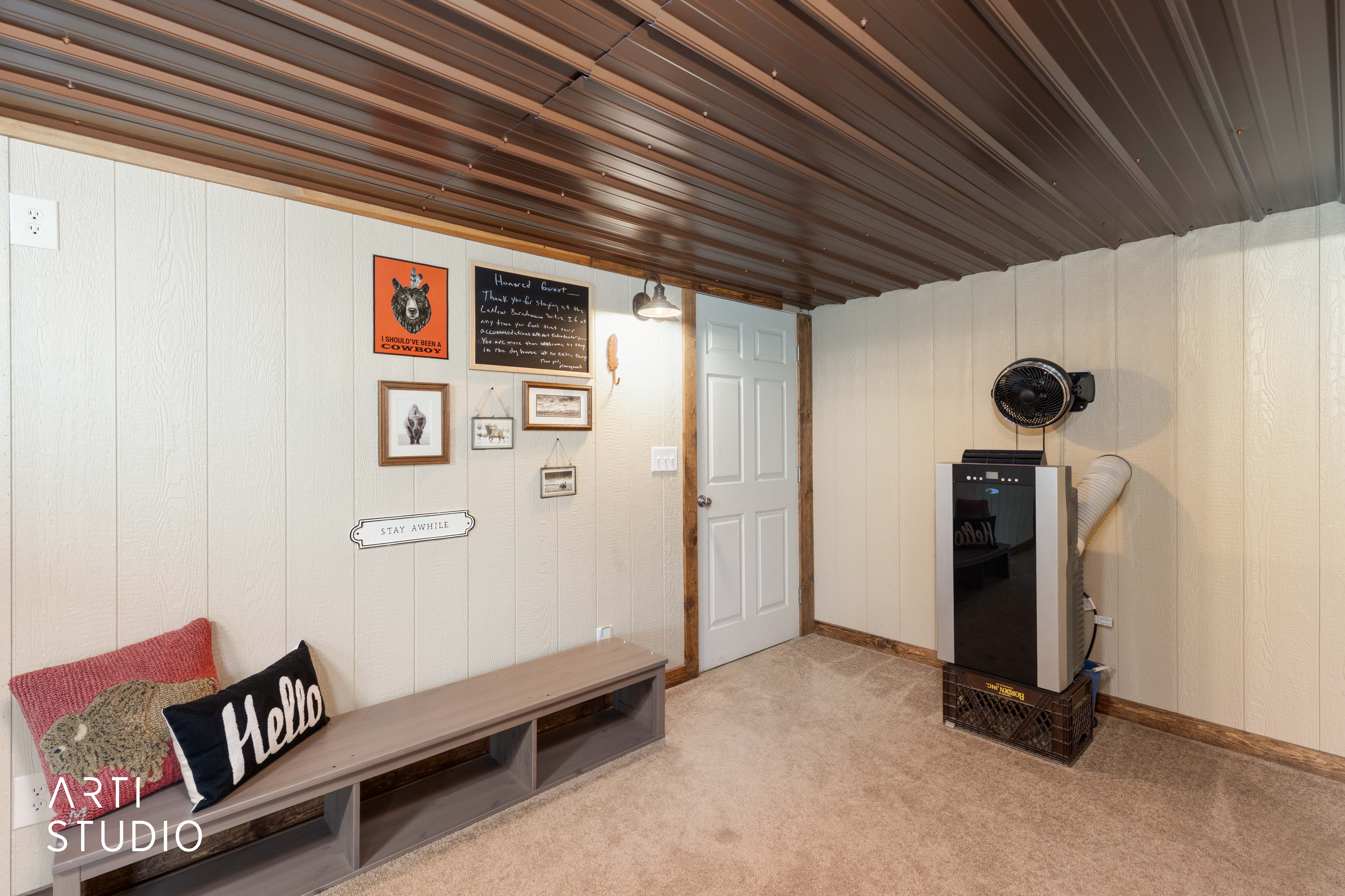 Interior space featuring light-colored vertical paneling, a corrugated metal ceiling, and a light brown carpeted floor