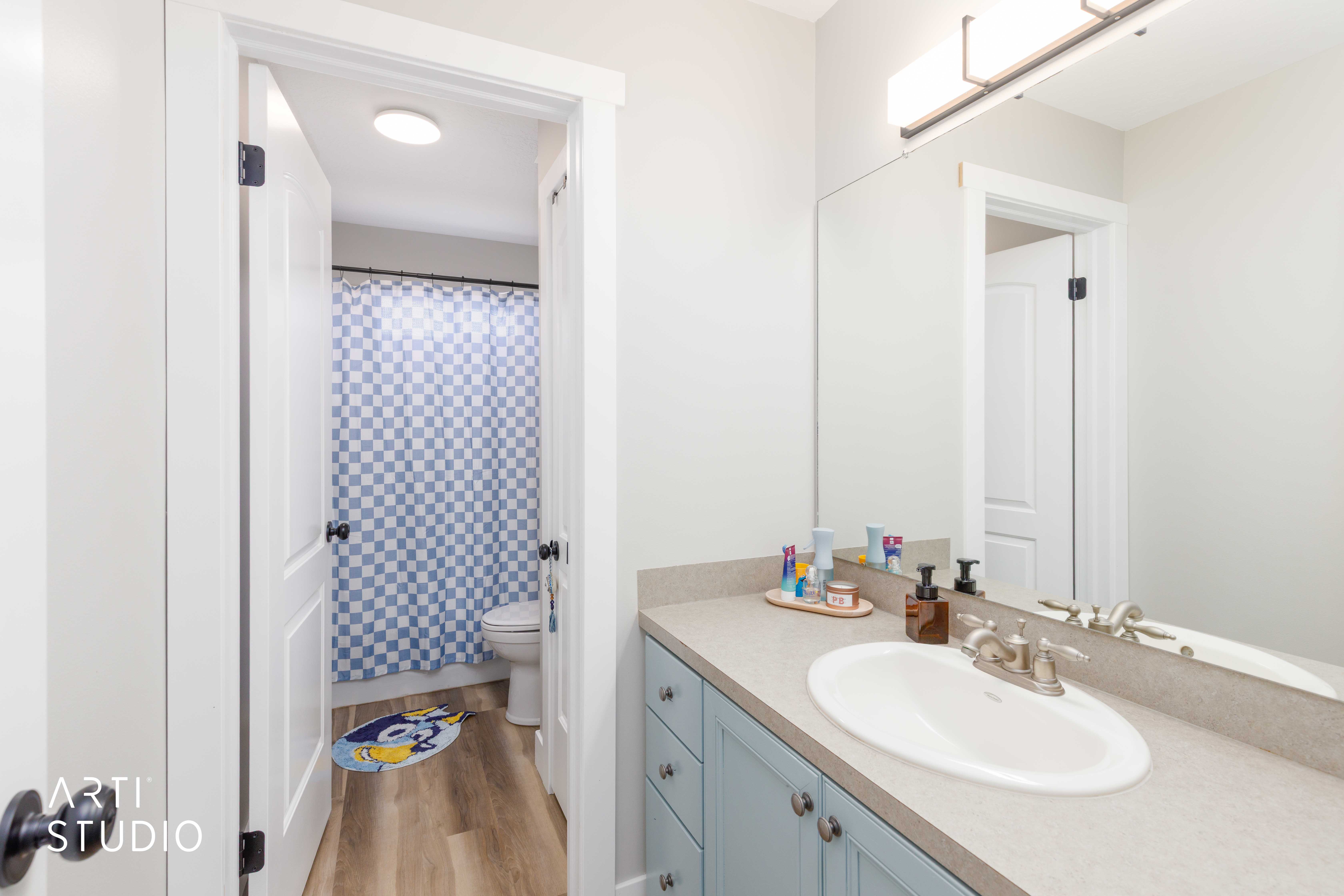 Bathroom vanity with a light countertop, integrated sink, and light blue cabinetry