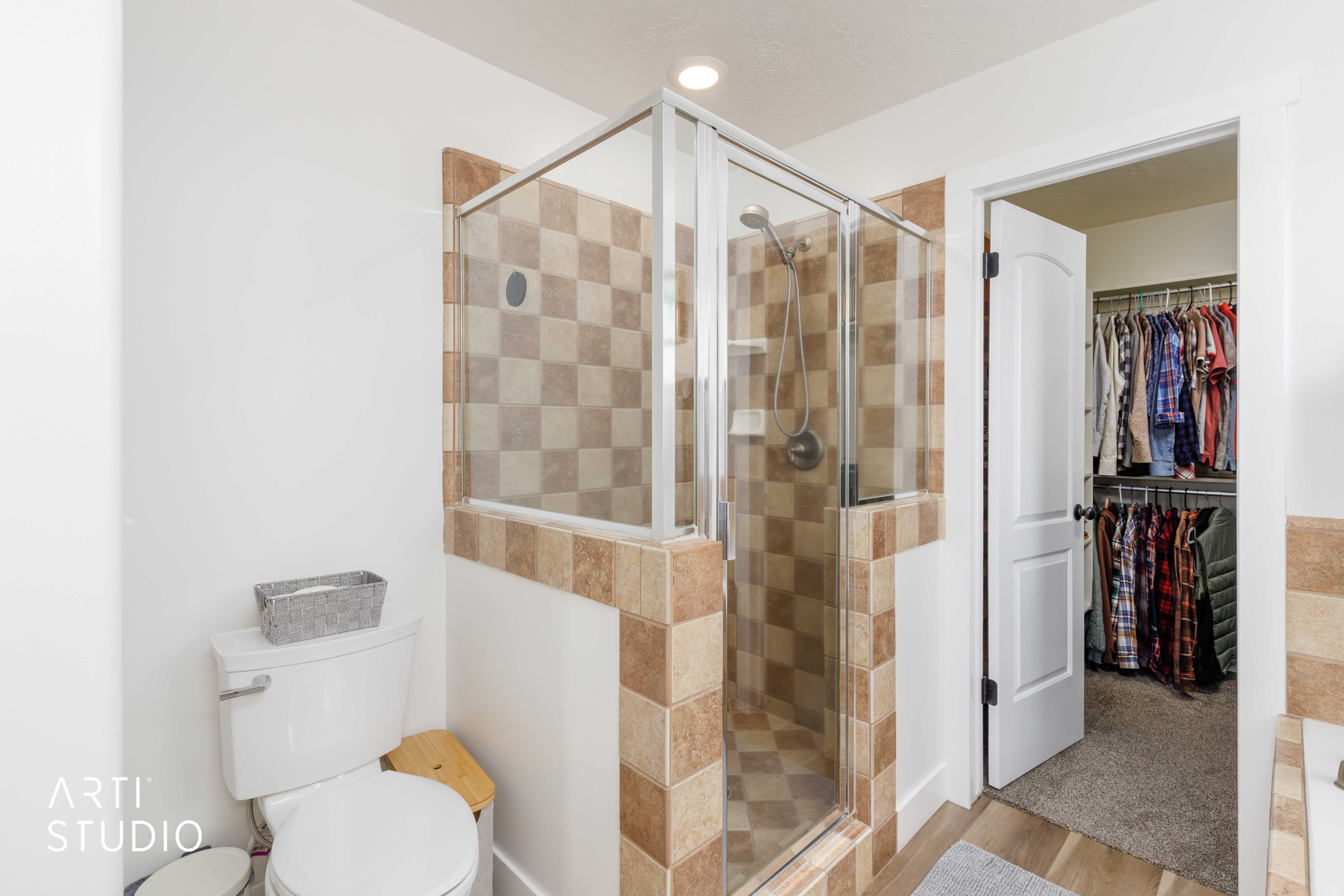 Walk-in shower with clear glass enclosure and checkerboard tile
