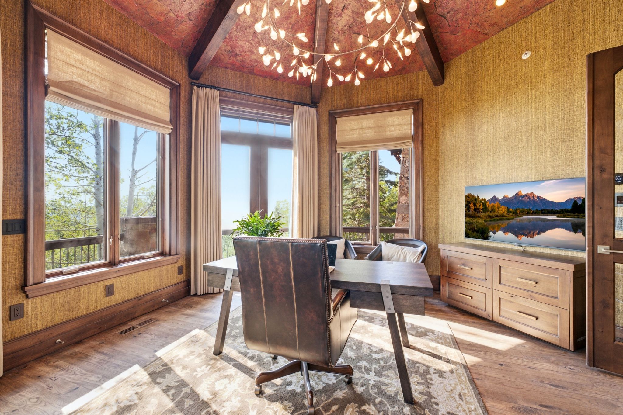 Spacious room featuring wood-finish flooring, textured wall coverings, and exposed ceiling beams