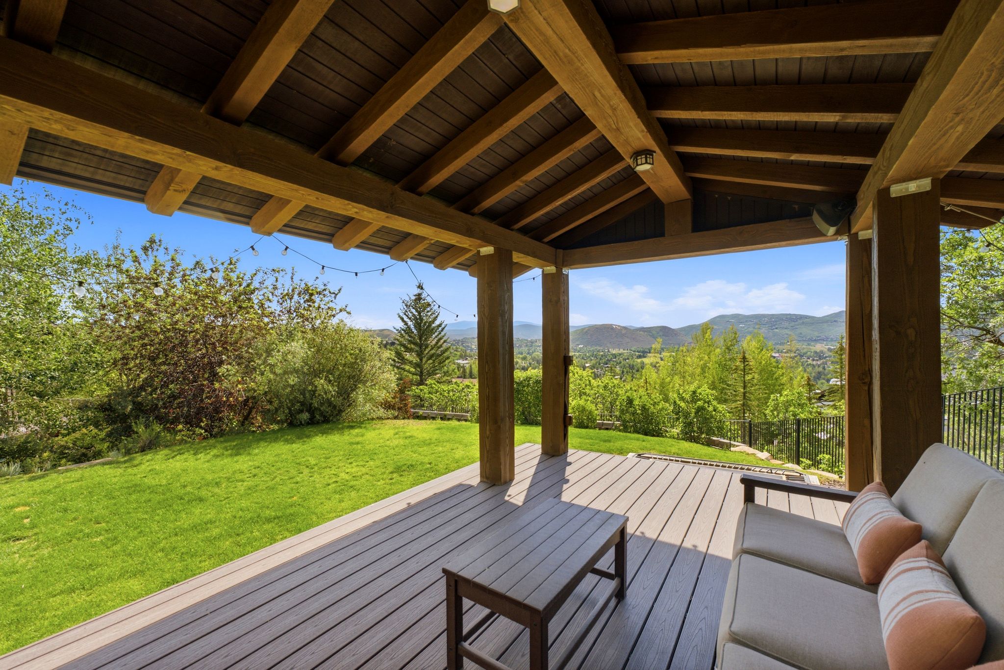 Covered outdoor deck featuring composite decking and exposed wood beam ceiling