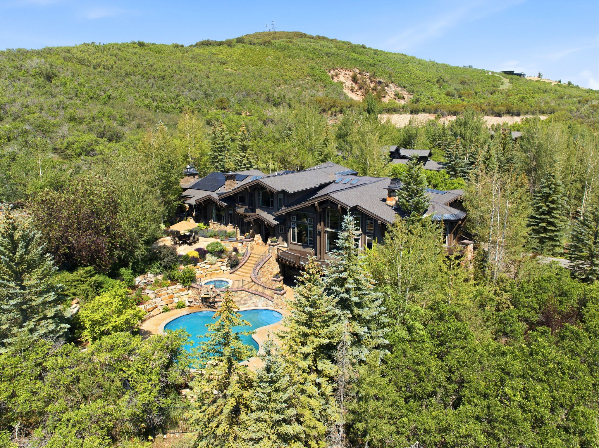 Expansive residential property featuring a multi-level layout, a freeform swimming pool, and an integrated spa