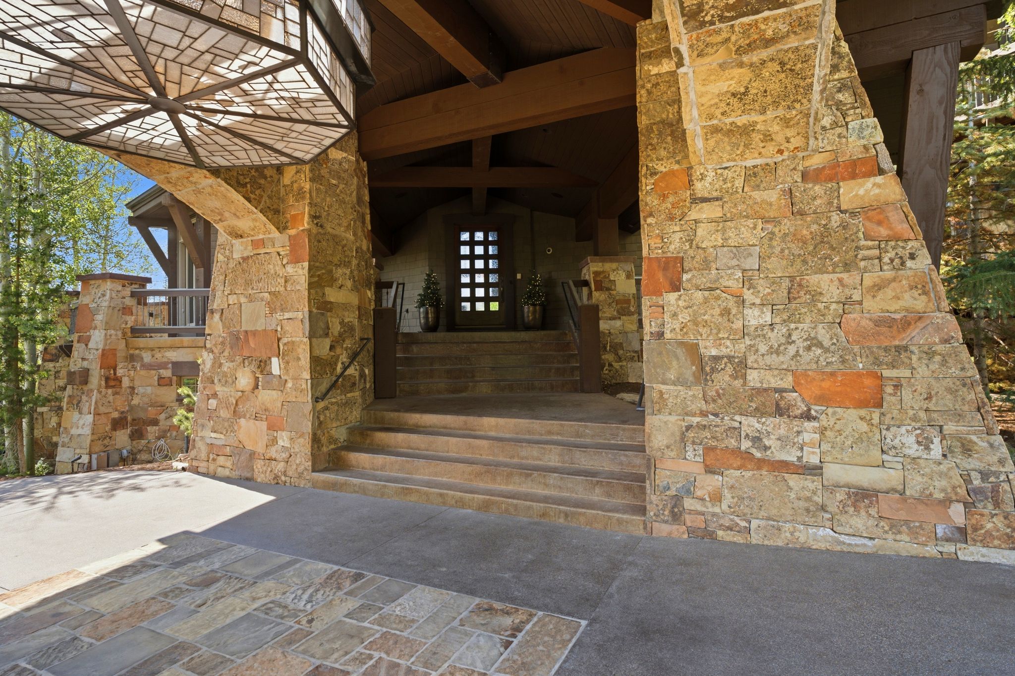 Stone exterior featuring a substantial porte-cochère with an integrated ceiling light fixture