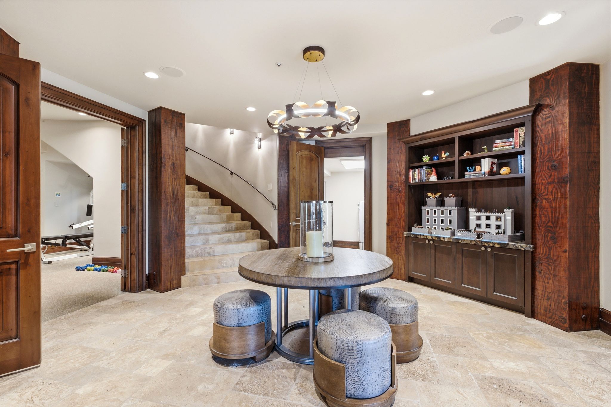 Spacious interior featuring tile flooring, a curved staircase with a dark wood handrail, and built-in shelving with cabinetry