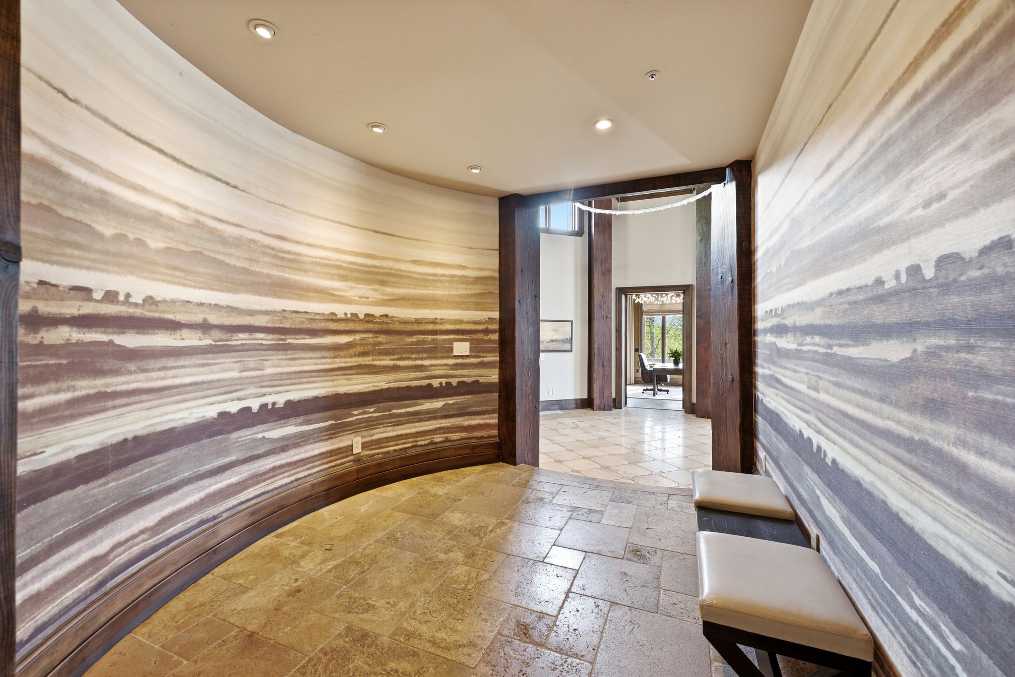 Curved hallway featuring a distinctive mural wall covering and recessed ceiling lighting