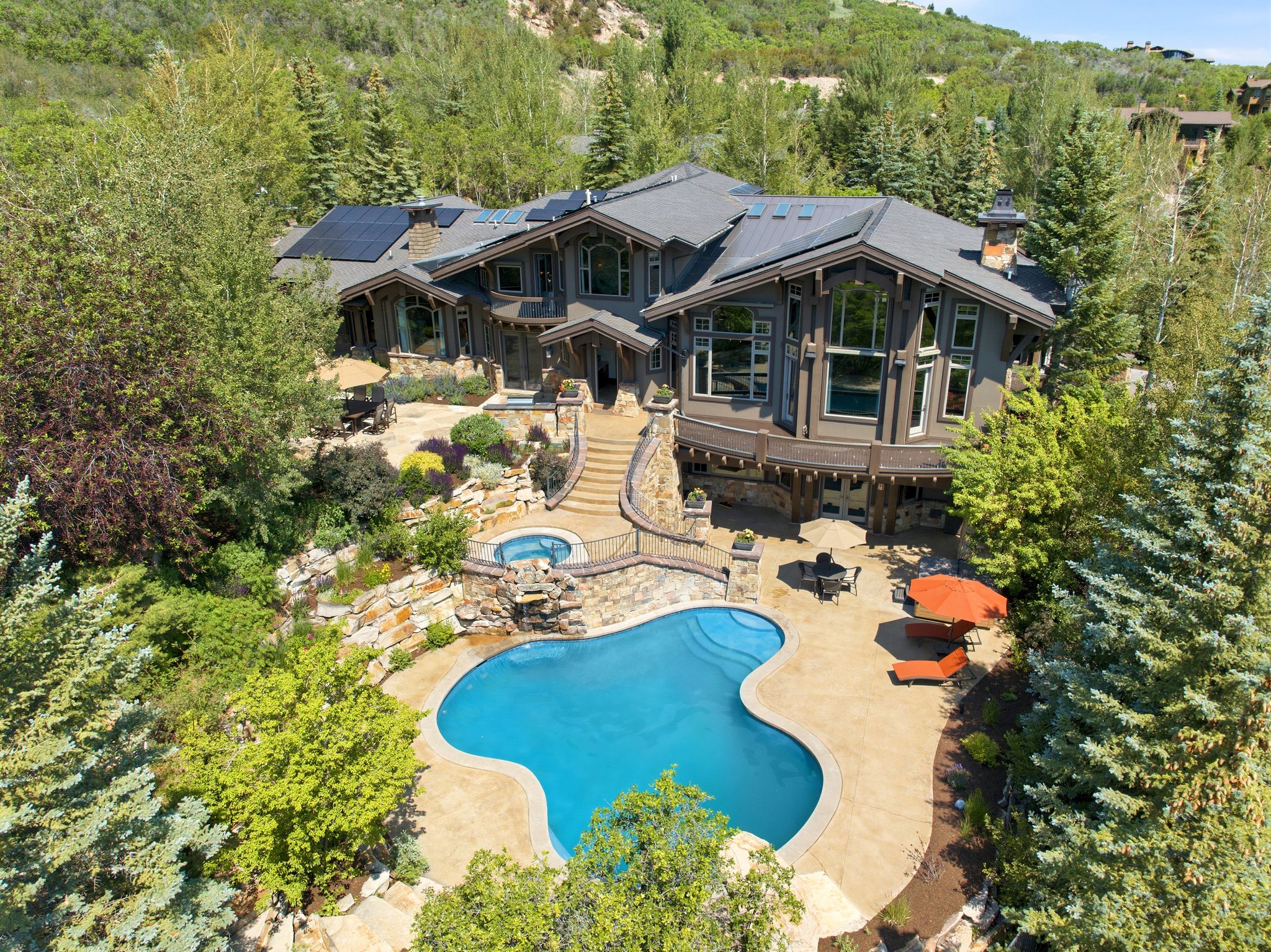 Mountain-style residence featuring a dark-toned exterior, stone accents, and a multi-level roofline
