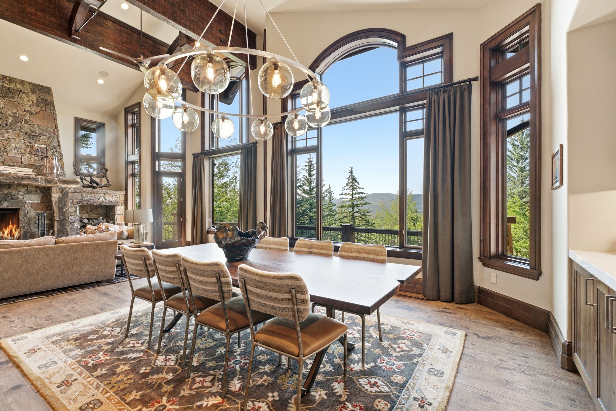 Dining area featuring wood-finish flooring, a large wood dining table, and a contemporary circular chandelier