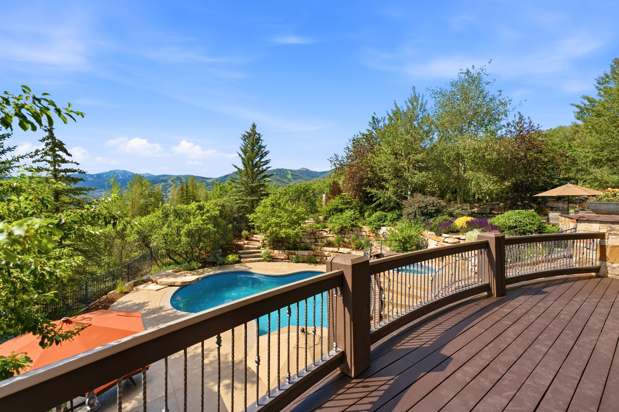 Expansive curved composite deck featuring metal balusters and wood-finish railings