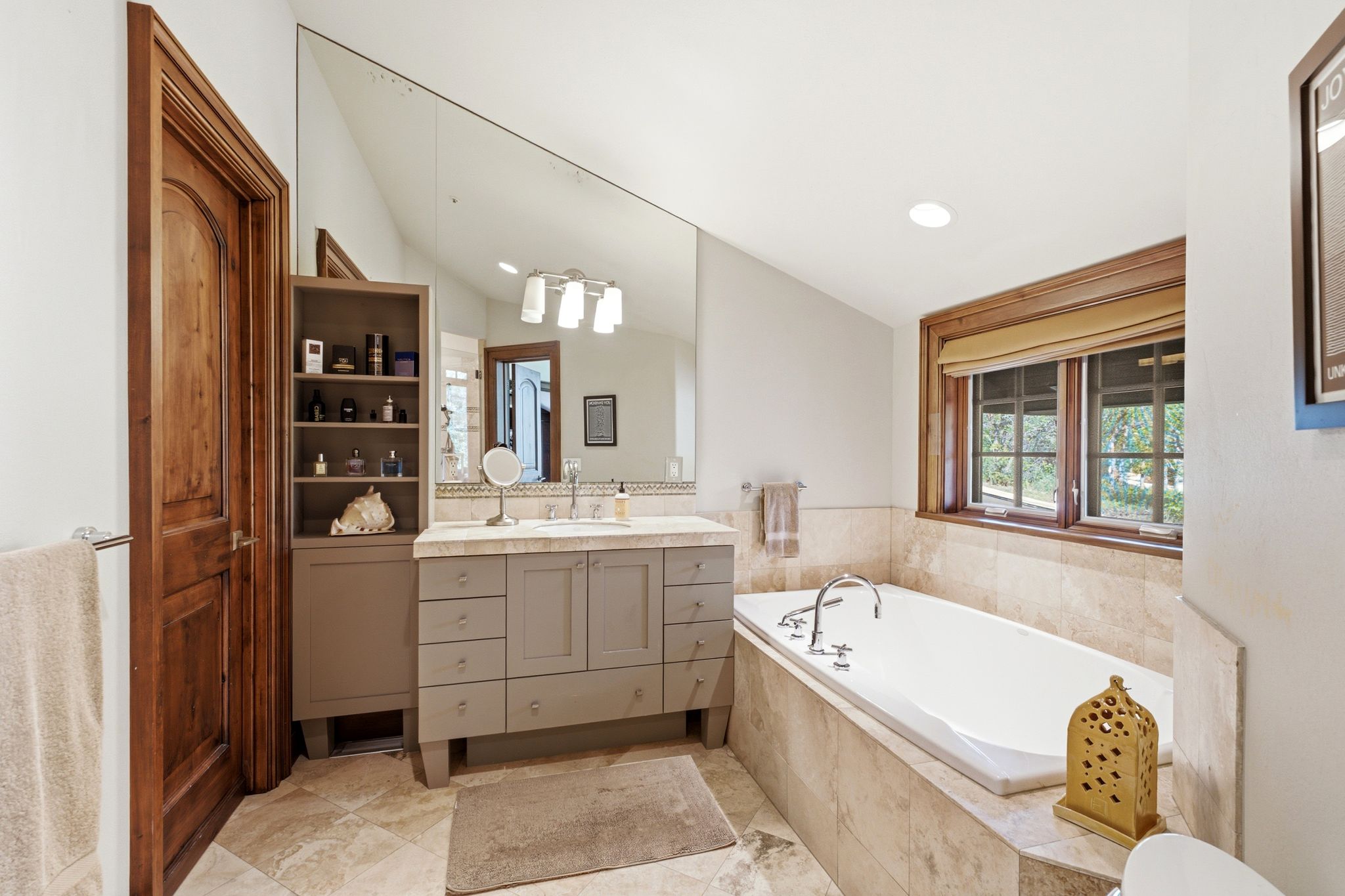 Bathroom featuring a built-in soaking tub, dual windows with wood trim, and a vanity with a light countertop