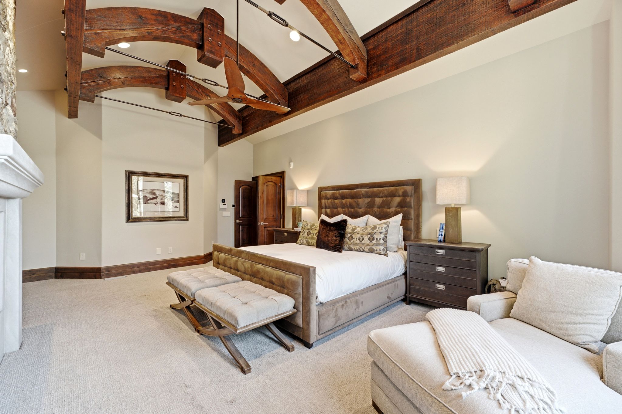 Vaulted ceiling featuring exposed wood beams and a ceiling fan