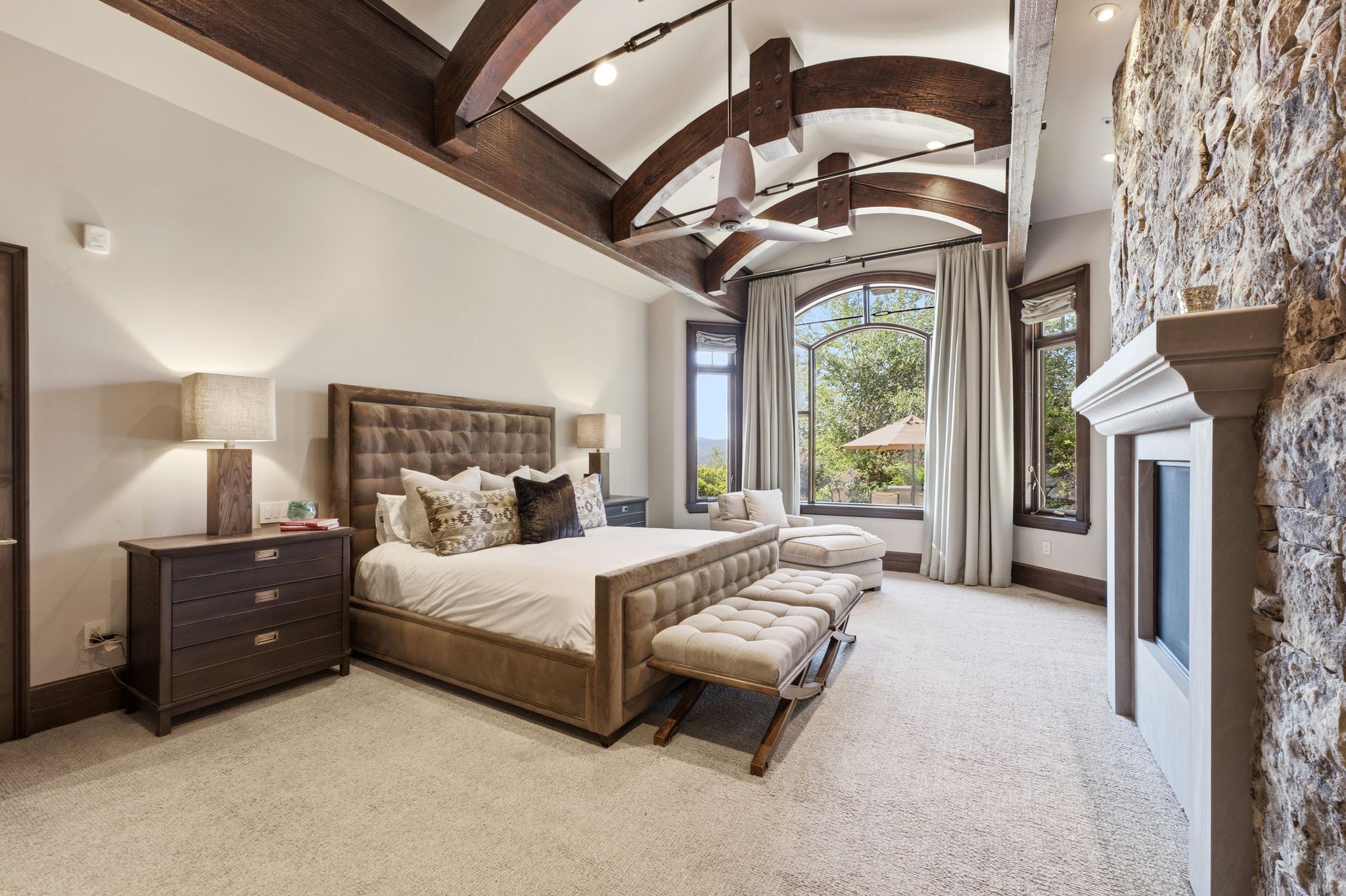 Vaulted ceiling featuring exposed wood beams and architectural lighting