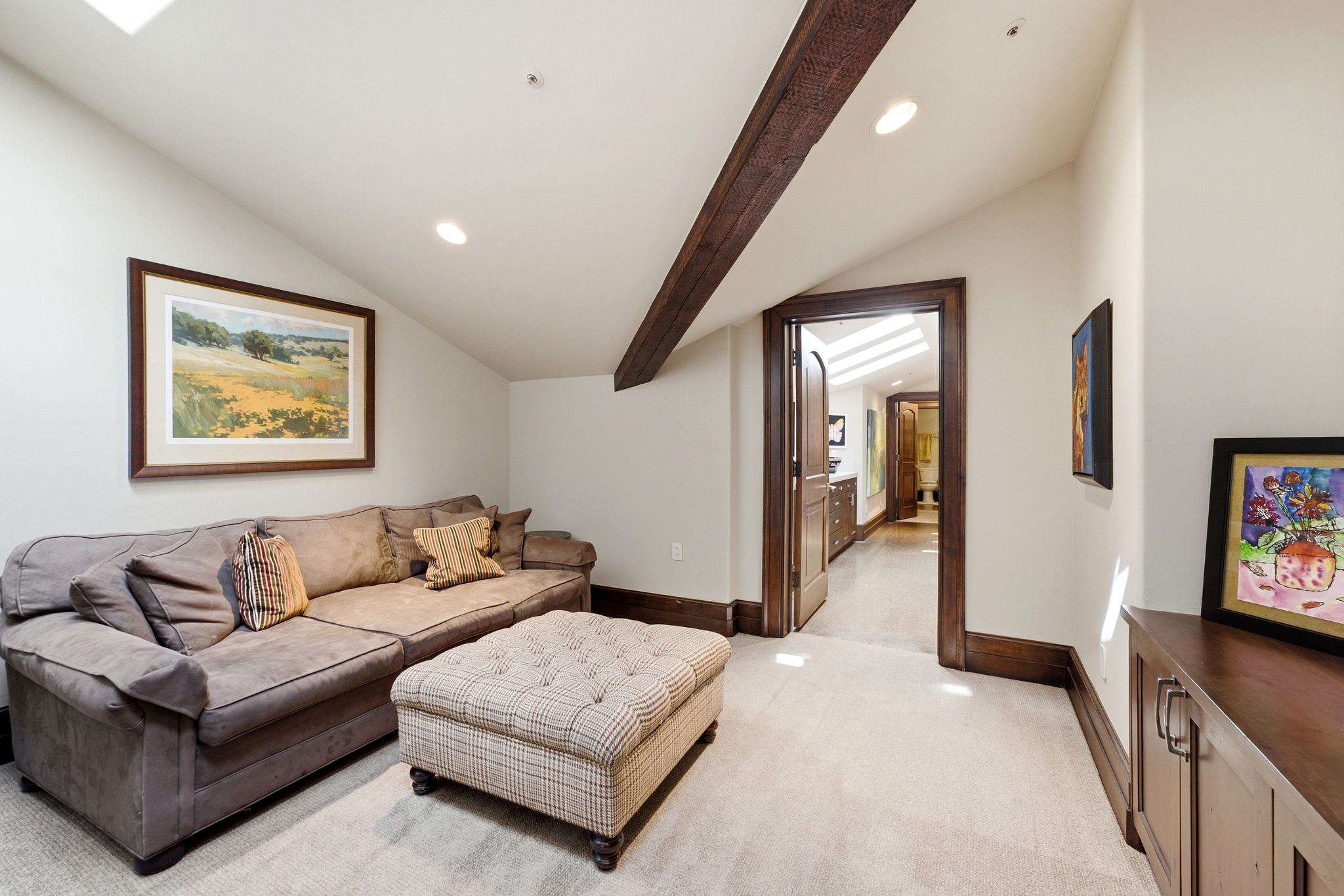 Vaulted ceiling with an exposed beam, recessed lighting, and a skylight