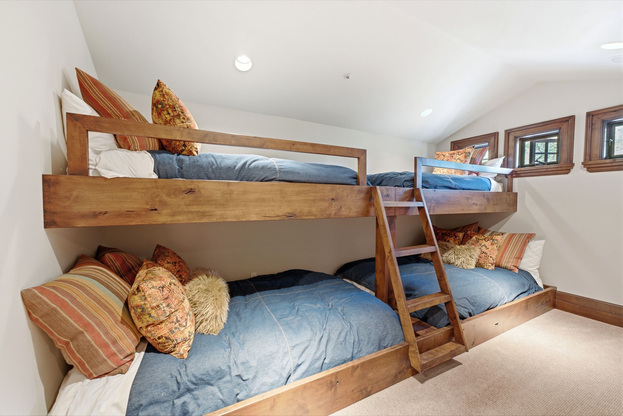Room featuring two sets of built-in bunk beds with wood-finish frames