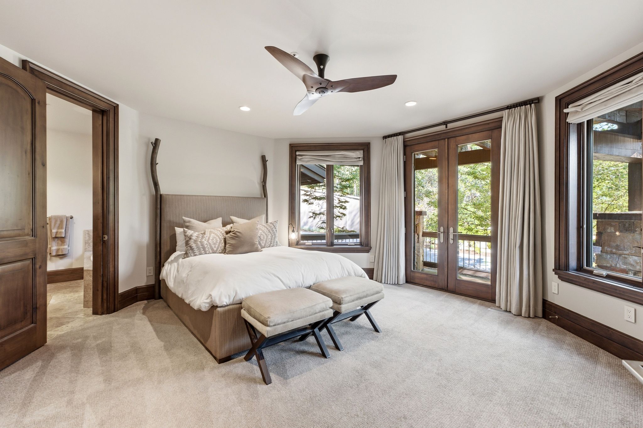 Wood-framed French doors opening to an exterior, complemented by two additional wood-framed windows