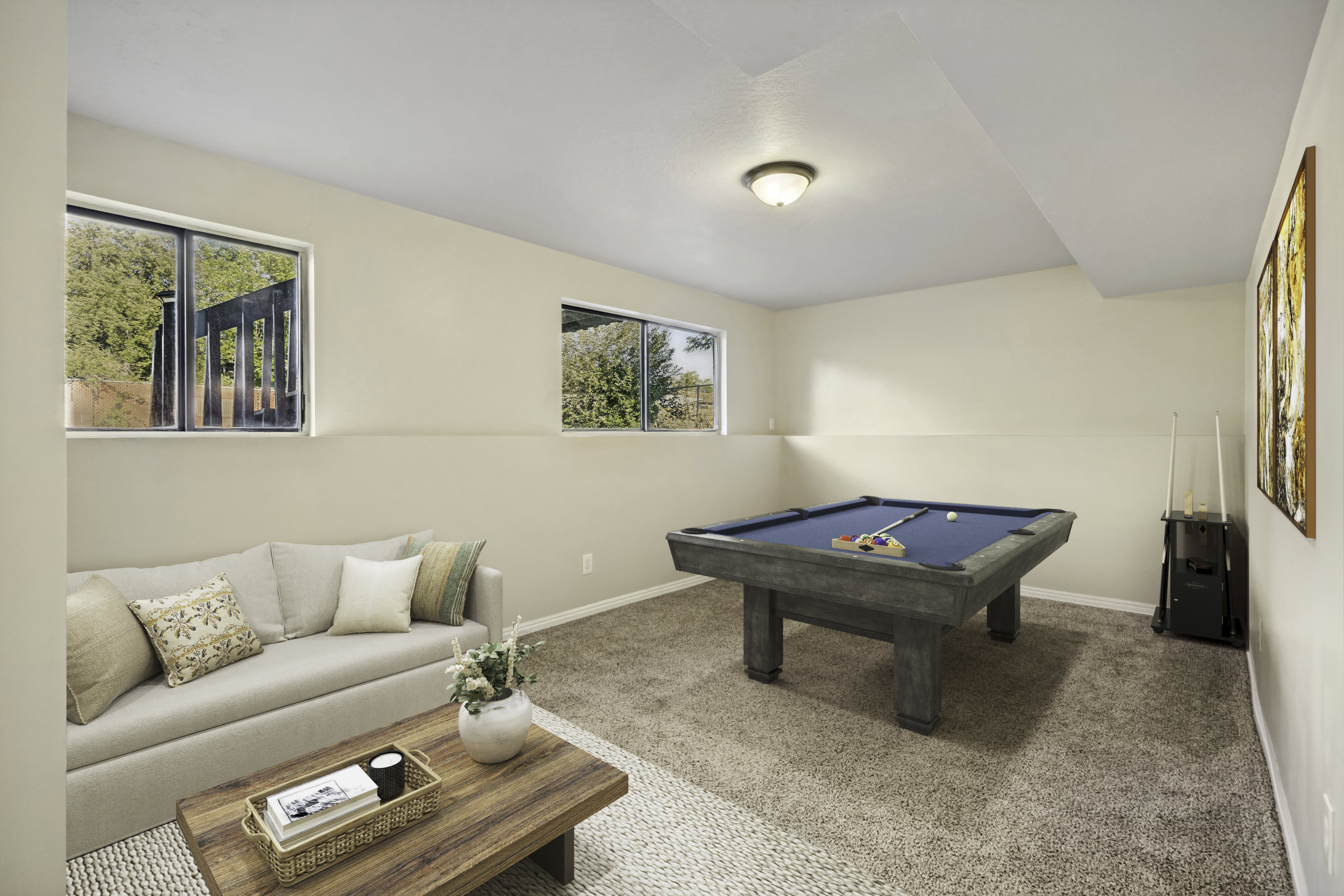 Virtually staged Finished basement area featuring warm neutral wall tones and a ceiling-mounted light fixture