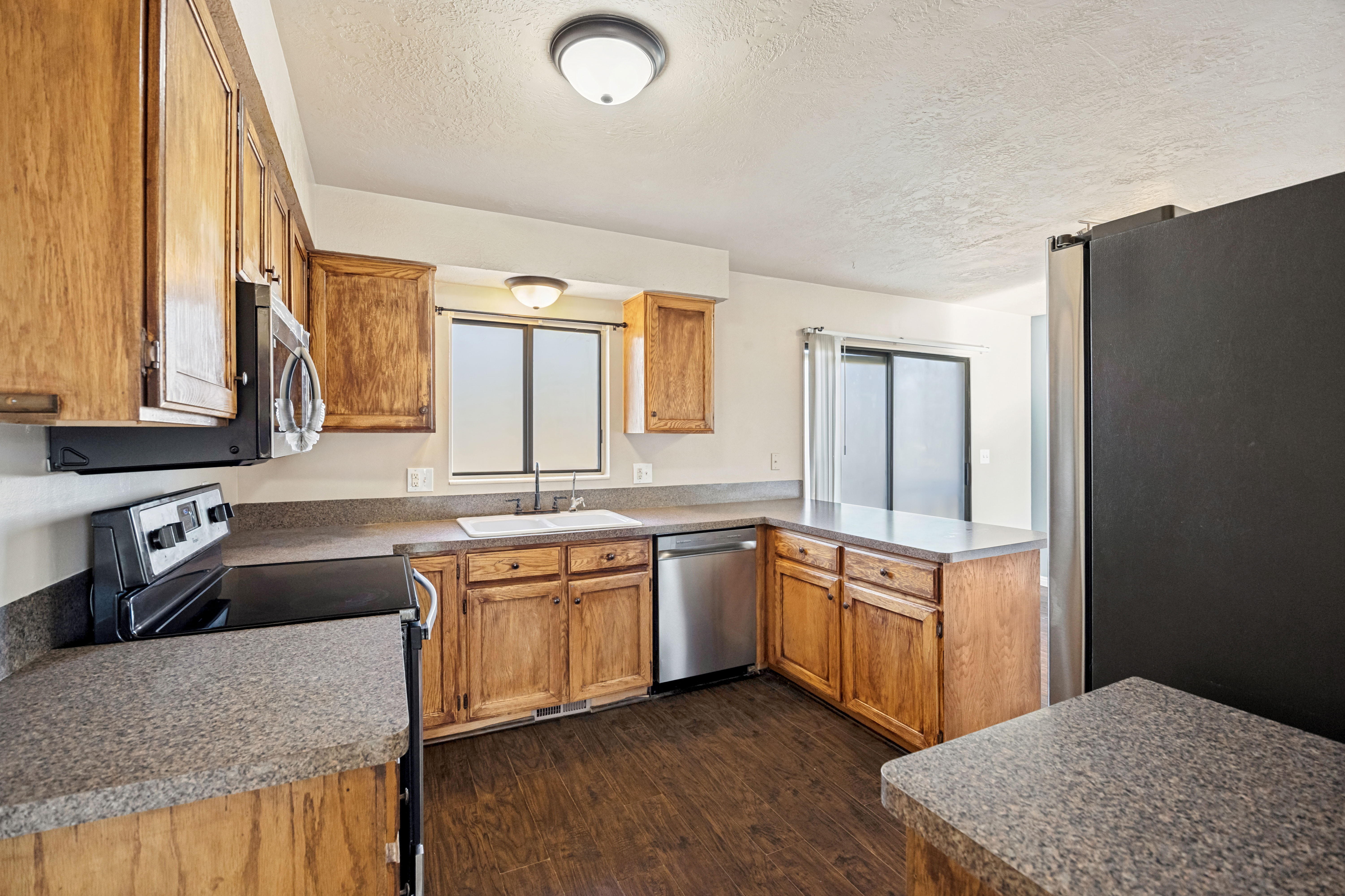Kitchen featuring wood-finish cabinetry and speckled countertops