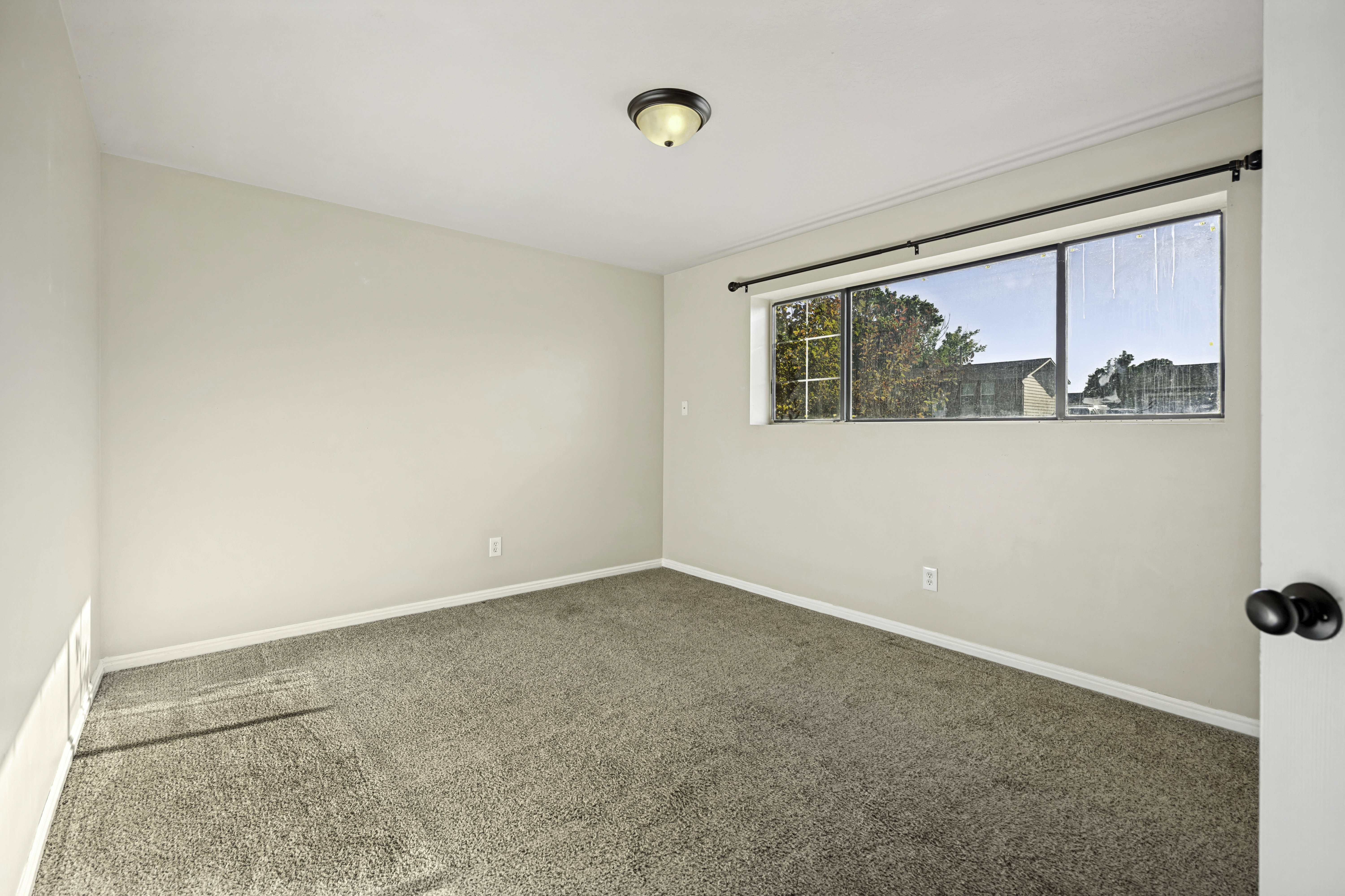 Neutral-toned walls complement plush carpeting